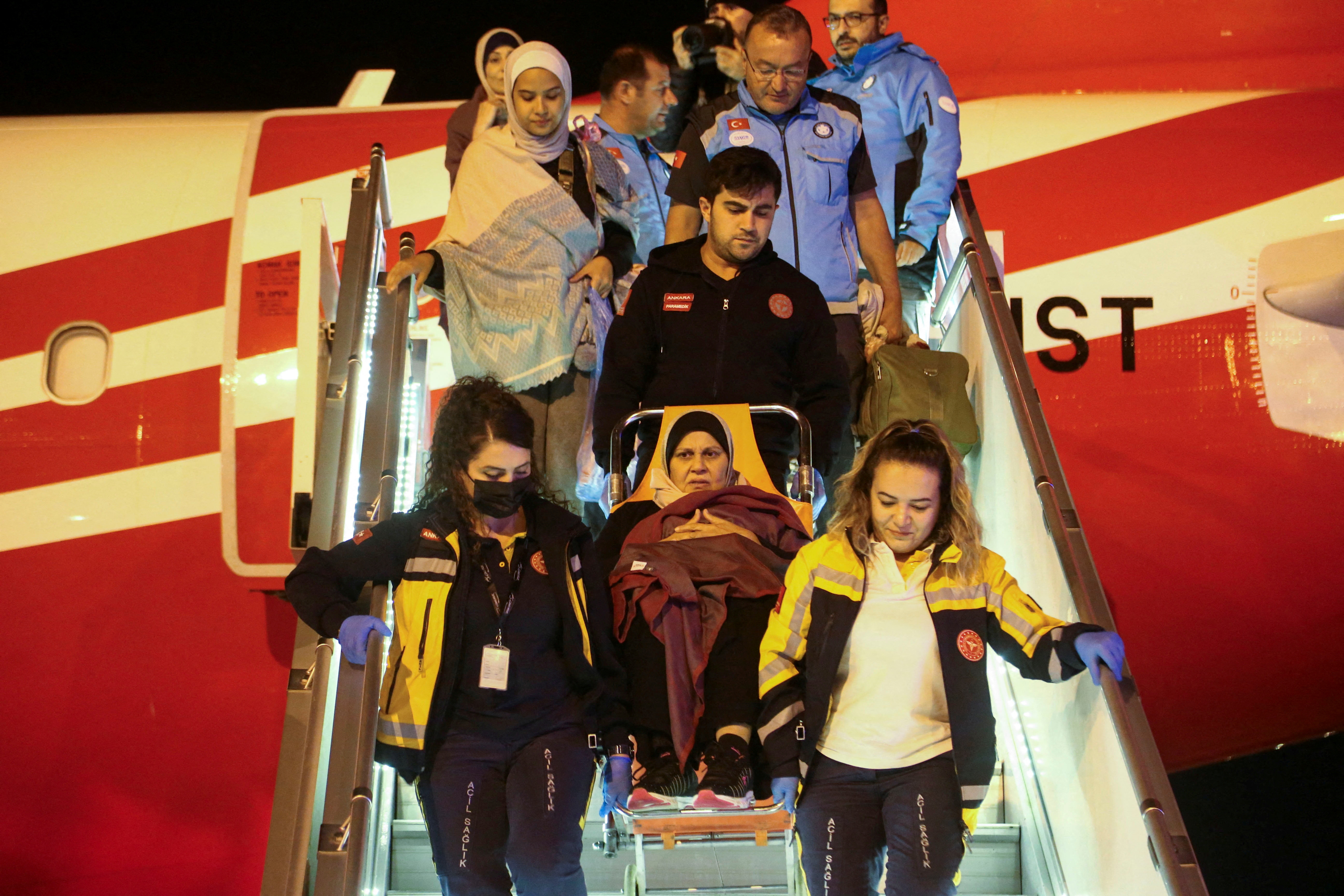 Medical staff carry a Palestinian cancer patient who was evacuated from Gaza to Egypt and brought to Türkiye by plane, at Esenboga Airport. /Reuters