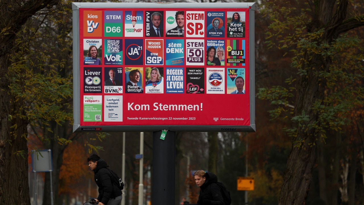People ride bikes past election campaign posters on a hoarding in Breda, Netherlands. /Yves Herman/Reuters