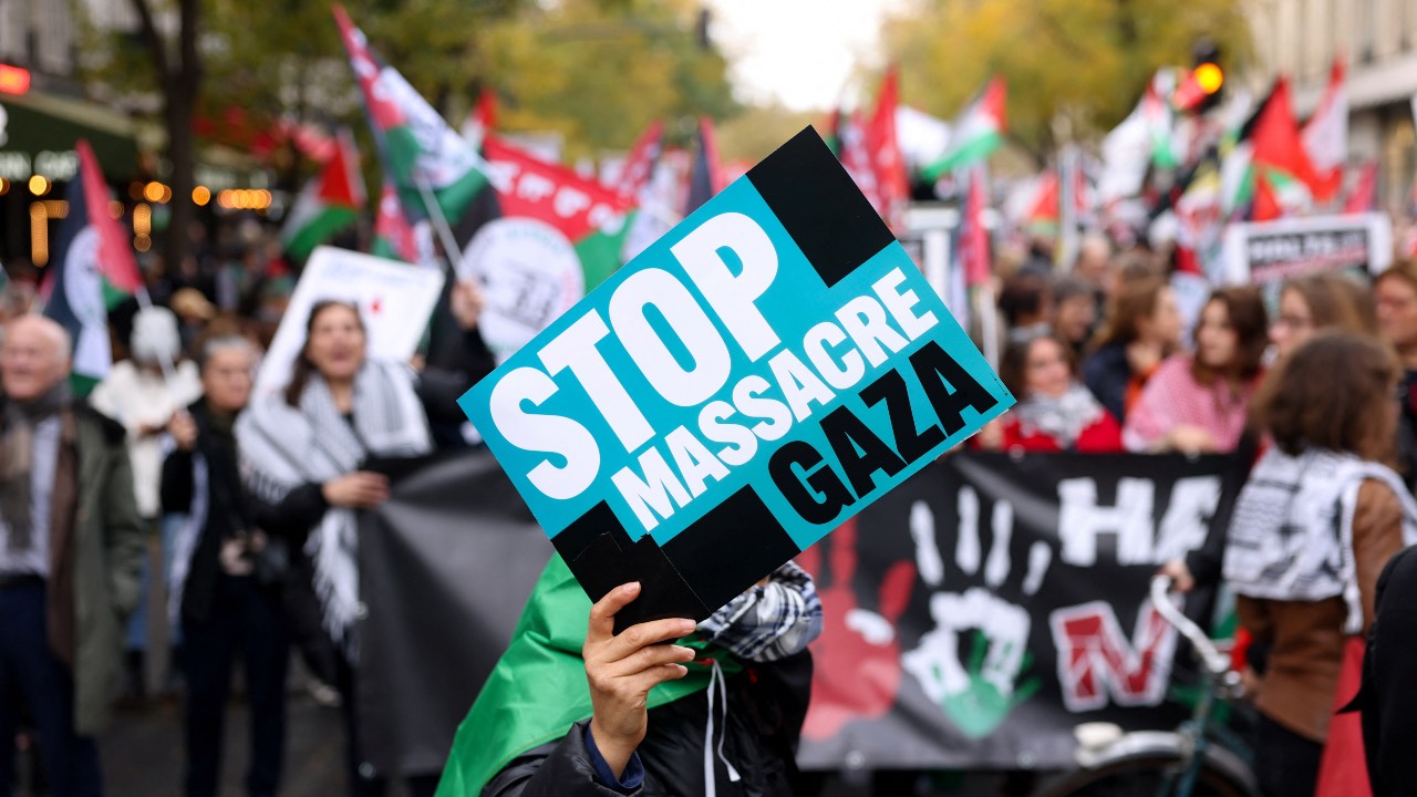 A person holds a placard during a demonstration demanding an immediate ceasefire in Gaza, in Paris, France. /Claudia Greco/Reuters