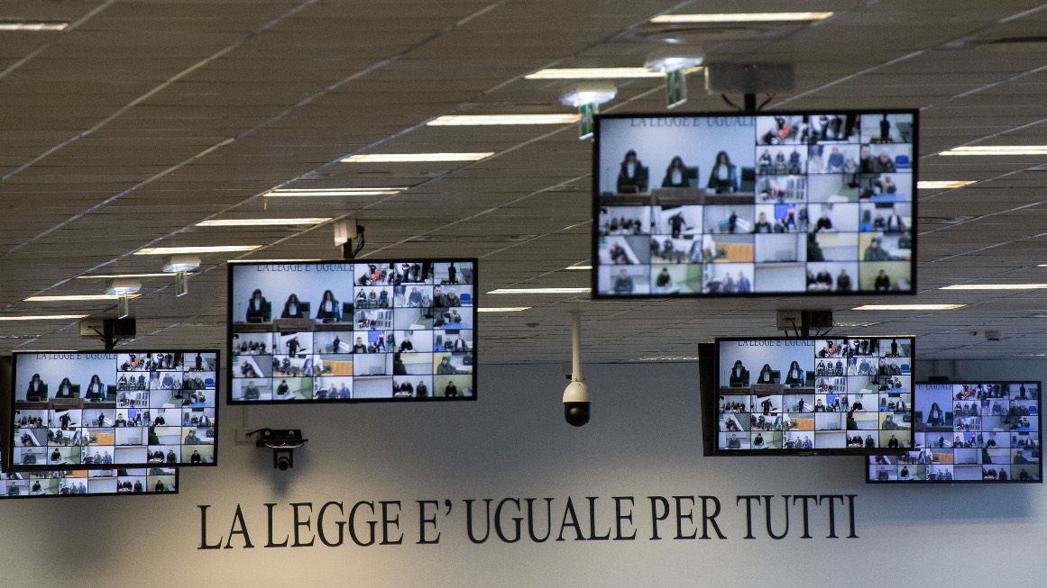 Courtroom monitors display the defendants listening to the verdict at the maxi mafia-trial in Lamezia Terme. /Gianluca Chininea/AFP