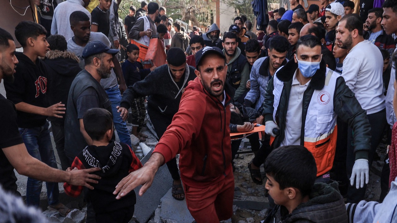 A Palestinian medic and civilians carry an injured man after an Israeli strike on Rafah, in the southern Gaza Strip. /Said Khatib/AFP
