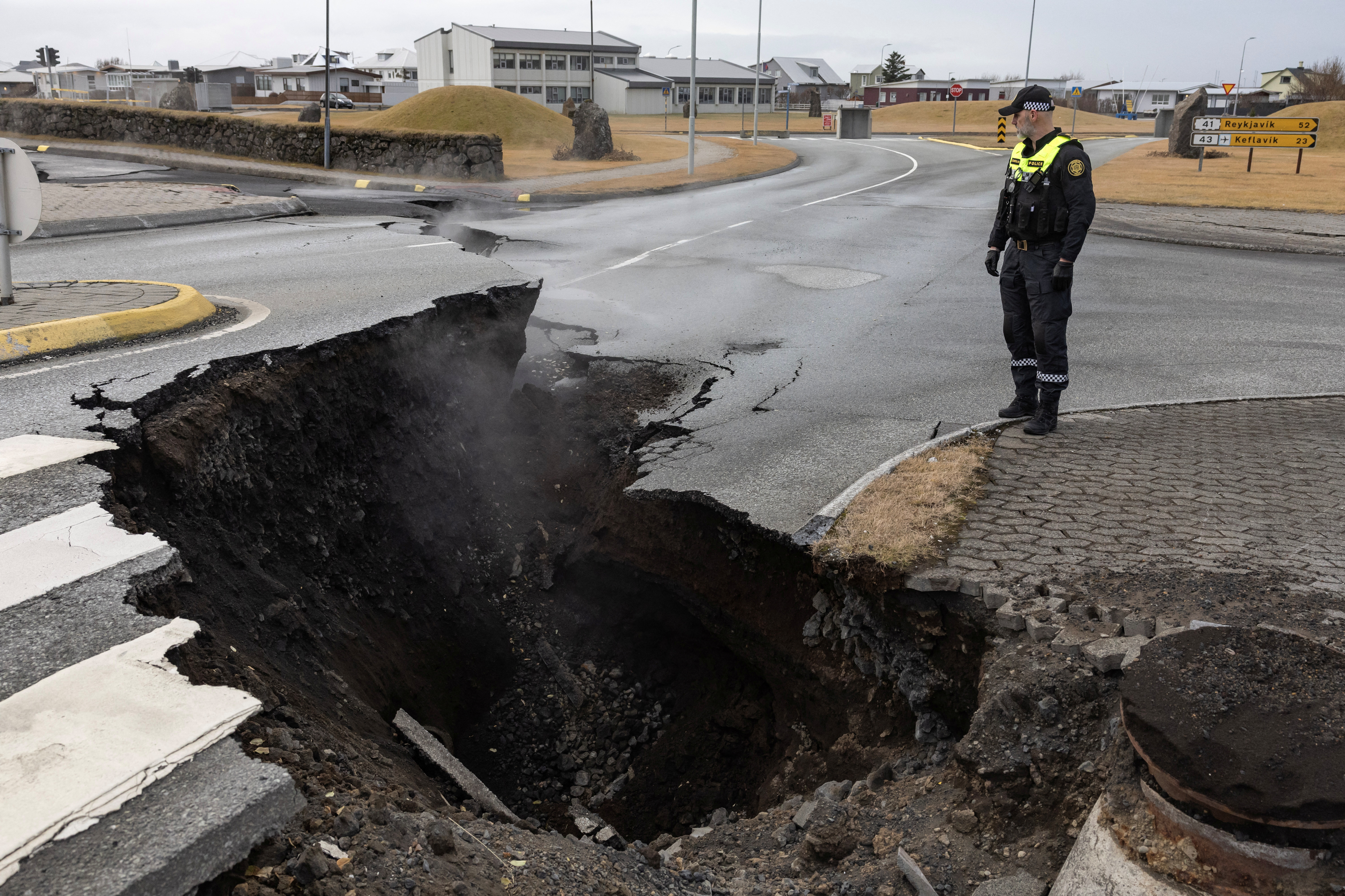 A police officer stands by the crack in a road in the fishing town of Grindavik, which was evacuated due to volcanic activity./Marko Djurica /Reuters
