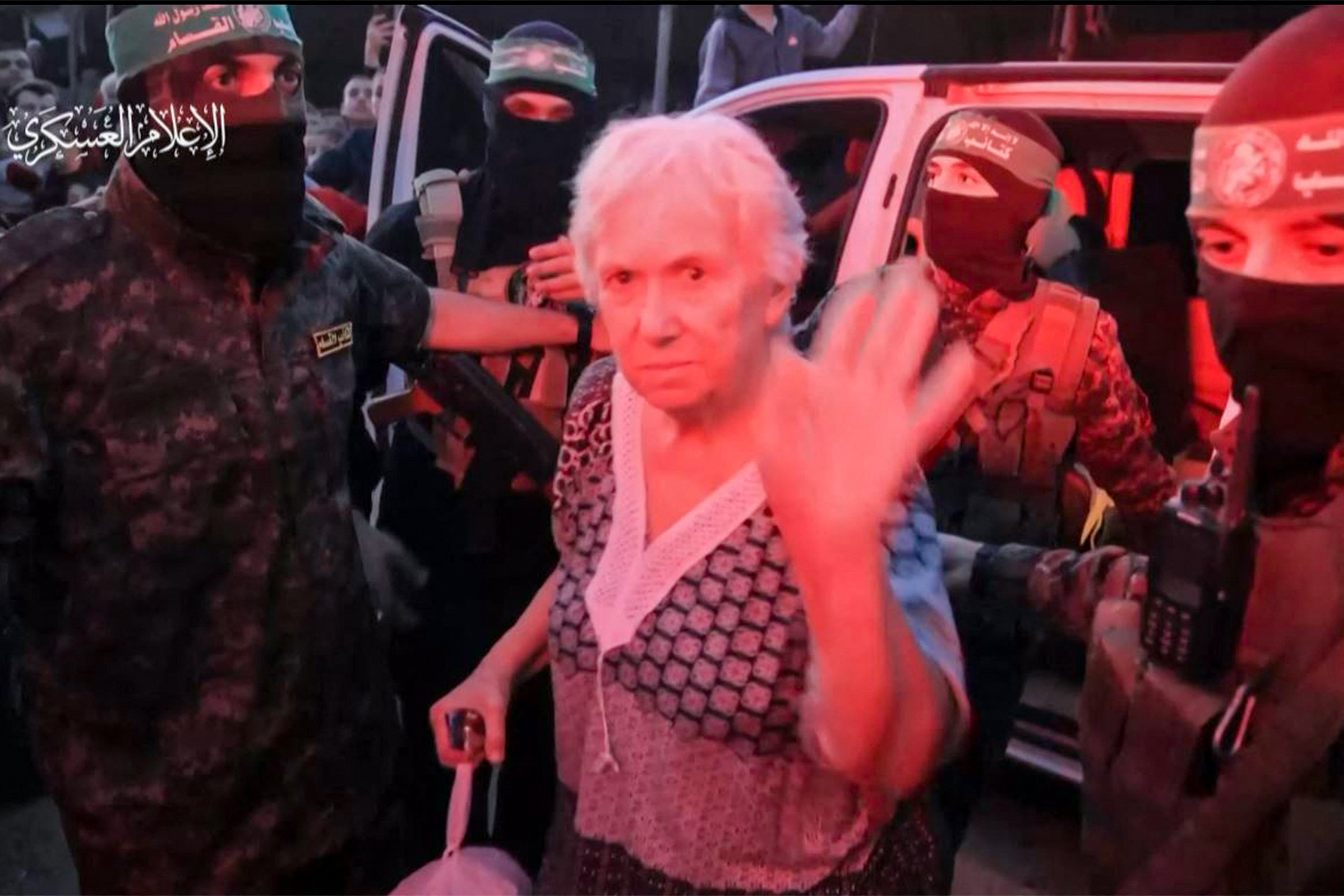 A hostage waves as she is handed over along with 23 others on Friday. /Hamas Media Office/AFP