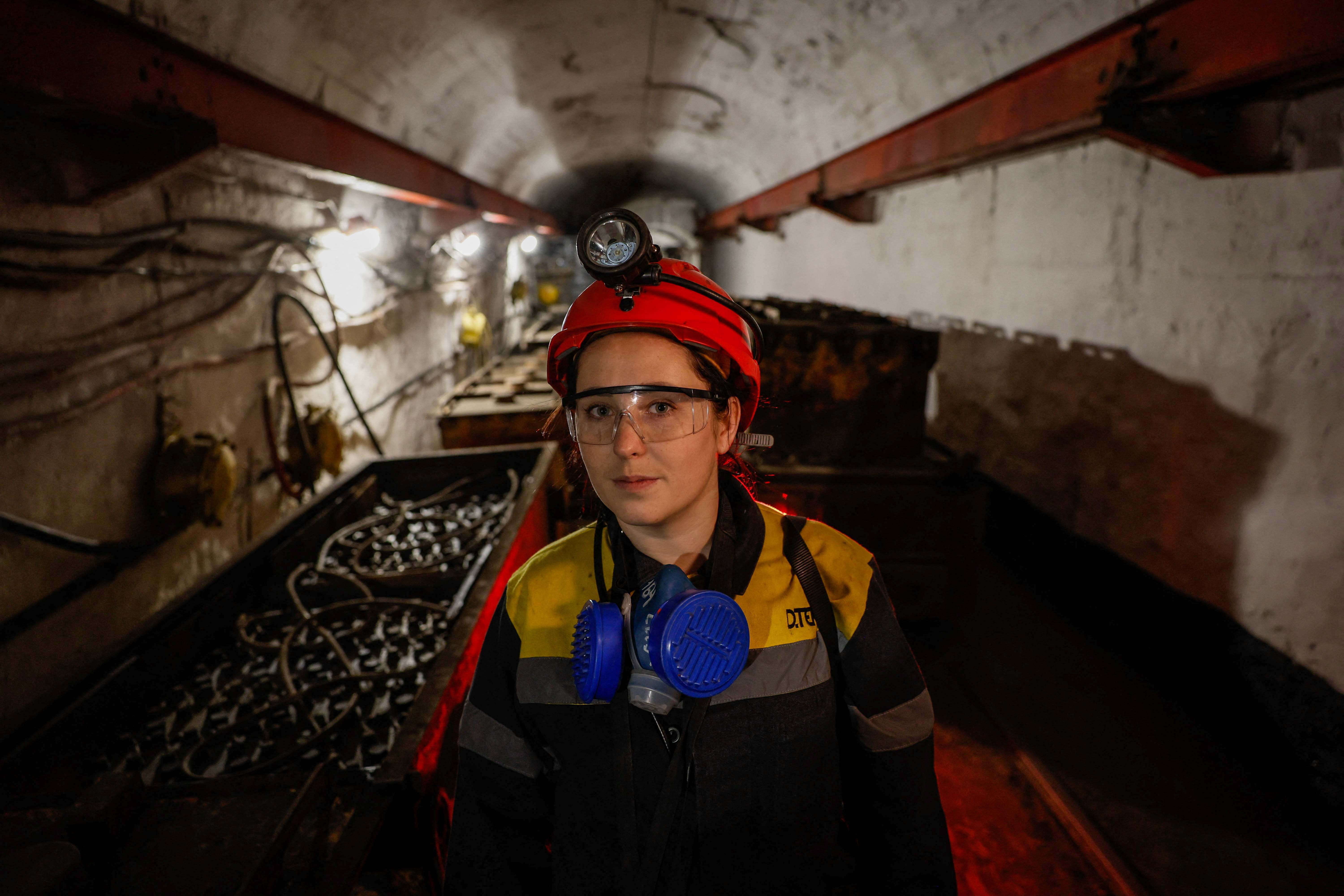 Krystyna stands next to a mine train battery. /Alina Smutko/Reuters