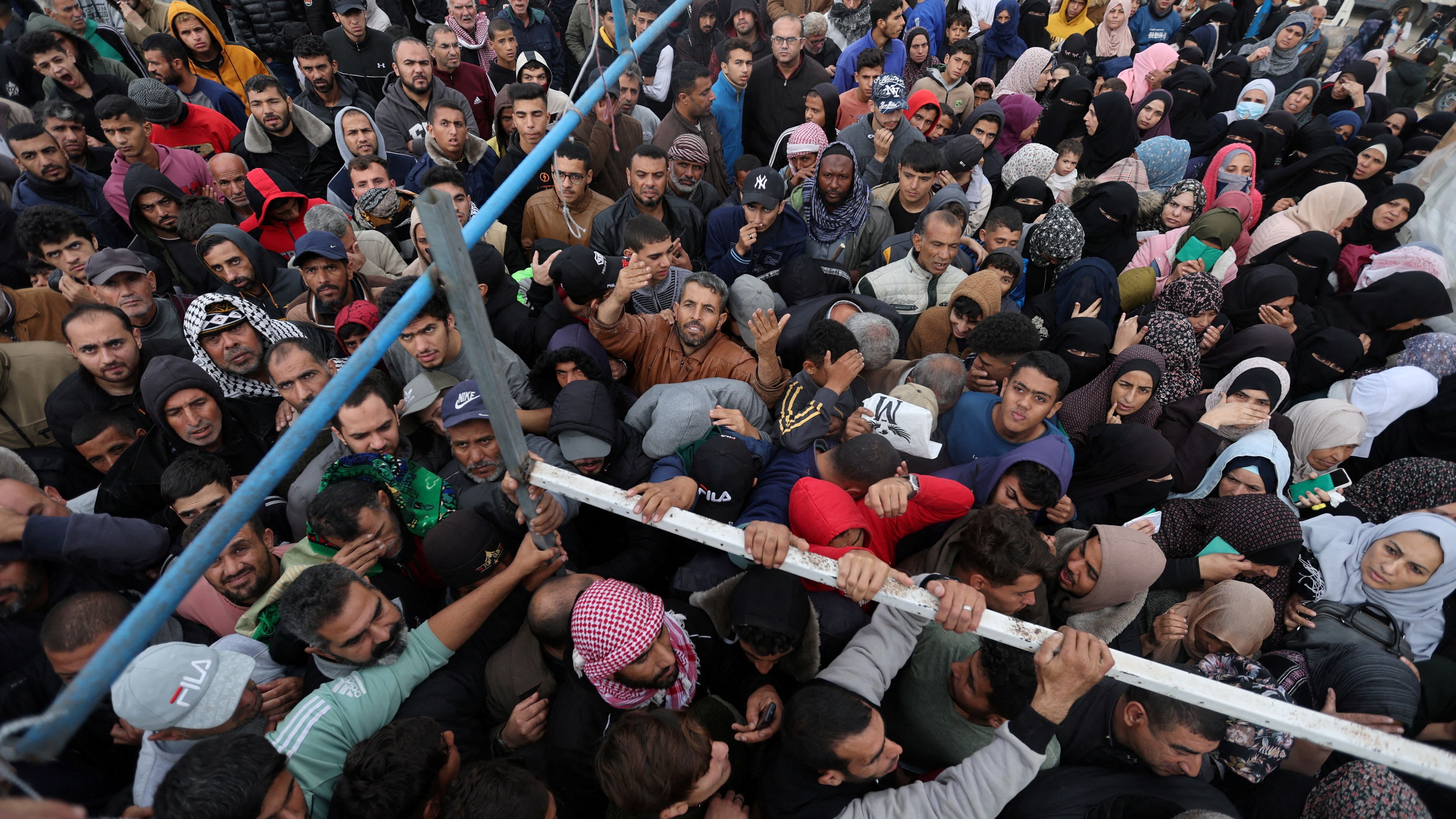 Palestinians wait for flour bags distributed by the UN Relief and Works Agency during the temporary truce. /Ibraheem Abu Mustafa/Reuters