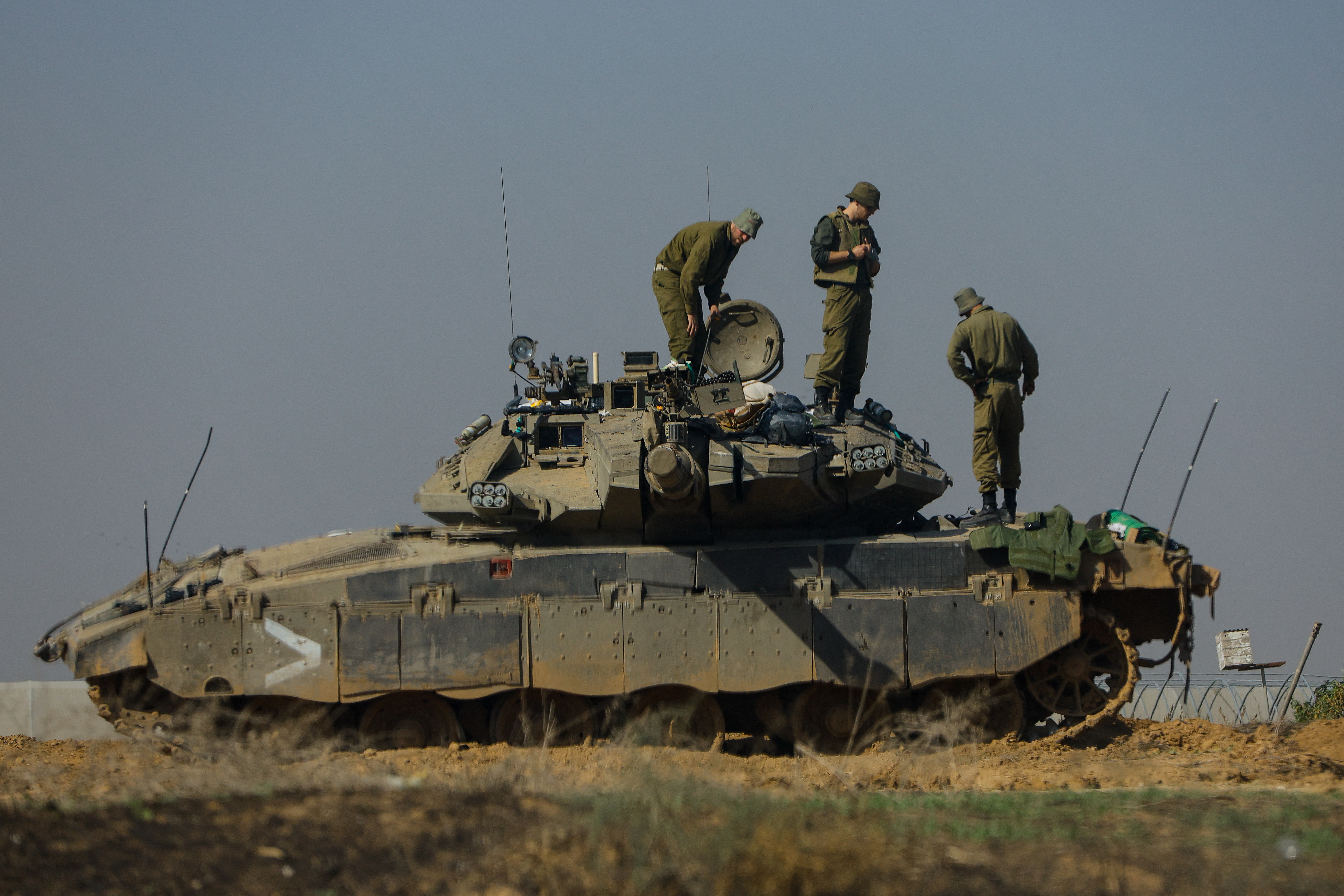 Israeli soldiers work on a tank near the border with Gaza. /Reuters/Alexander Ermochenko.