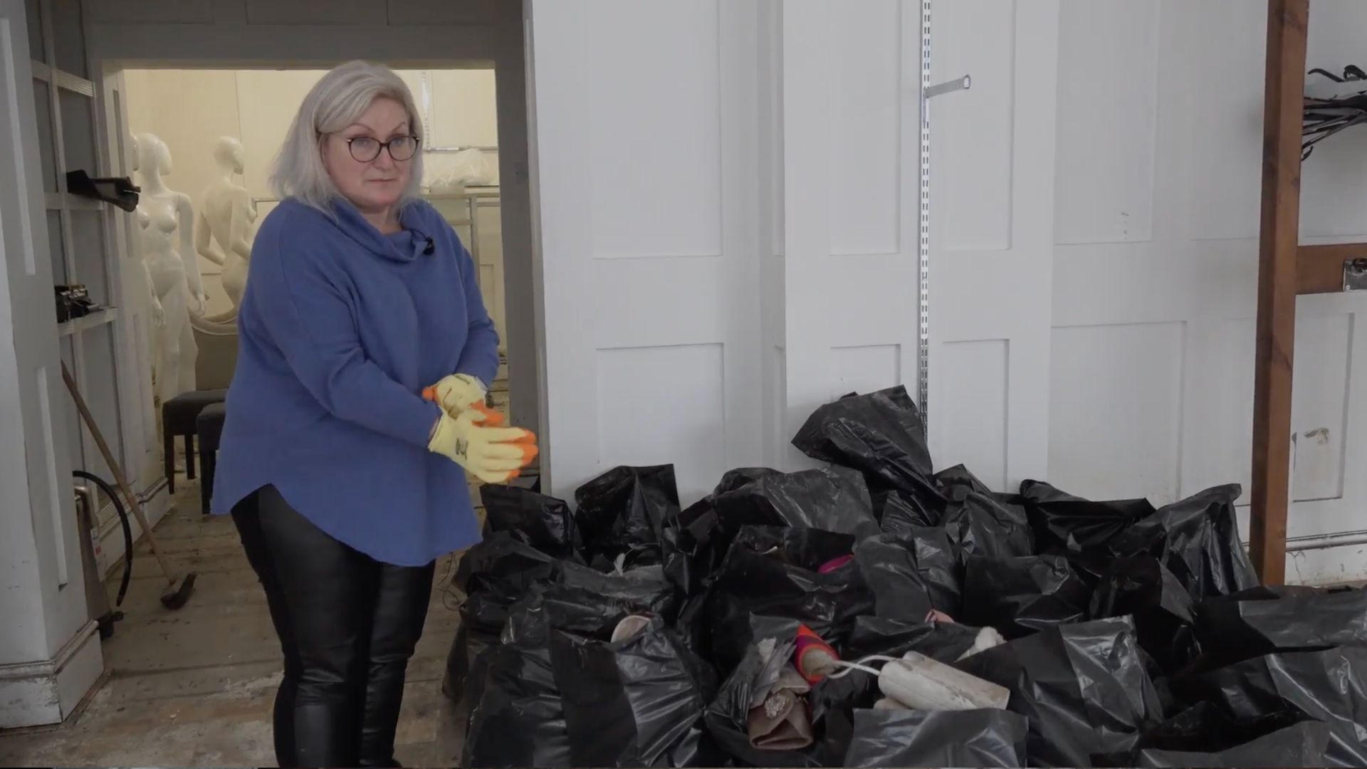 Anne-Marie White cleaning up her high-end clothing store Blanc after devastating floods. /CGTN