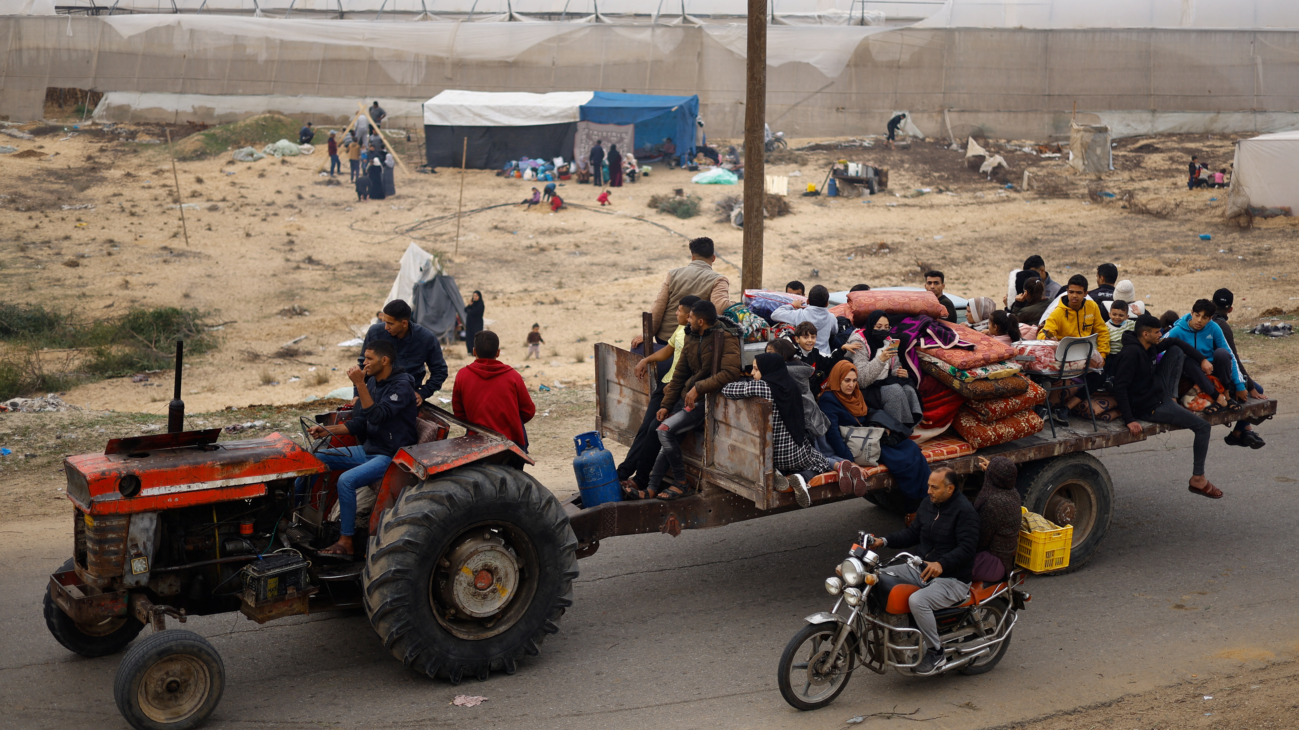 People ride a trailer near a new camp sheltering displaced Palestinians who fled their houses due to Israeli strikes in Rafah. /Mohammed Salem/Reuters