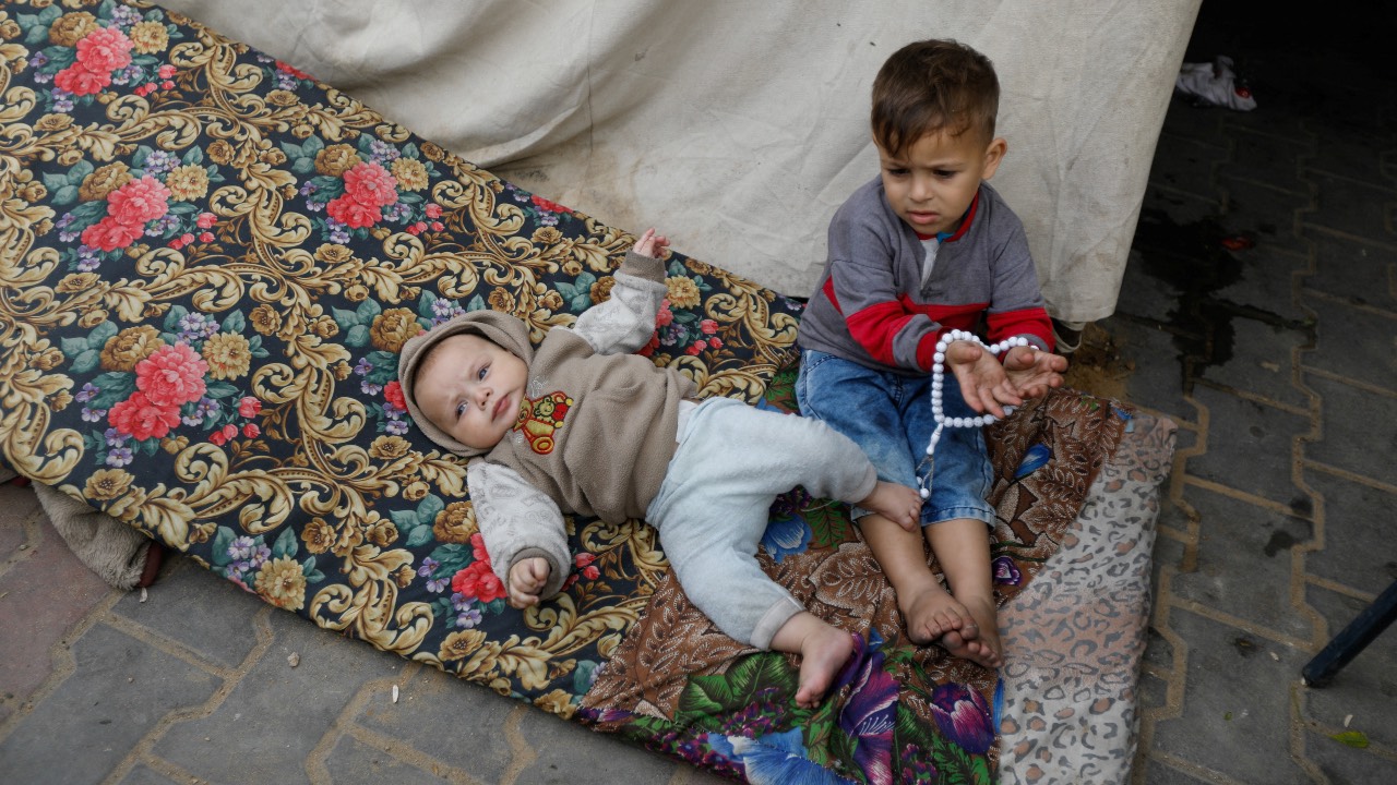 Palestinian infant Yazan Rehan lies on a mattress at a school sheltering people who fled their houses due to Israeli strikes, in Rafah. /Saleh Salem/Reuters