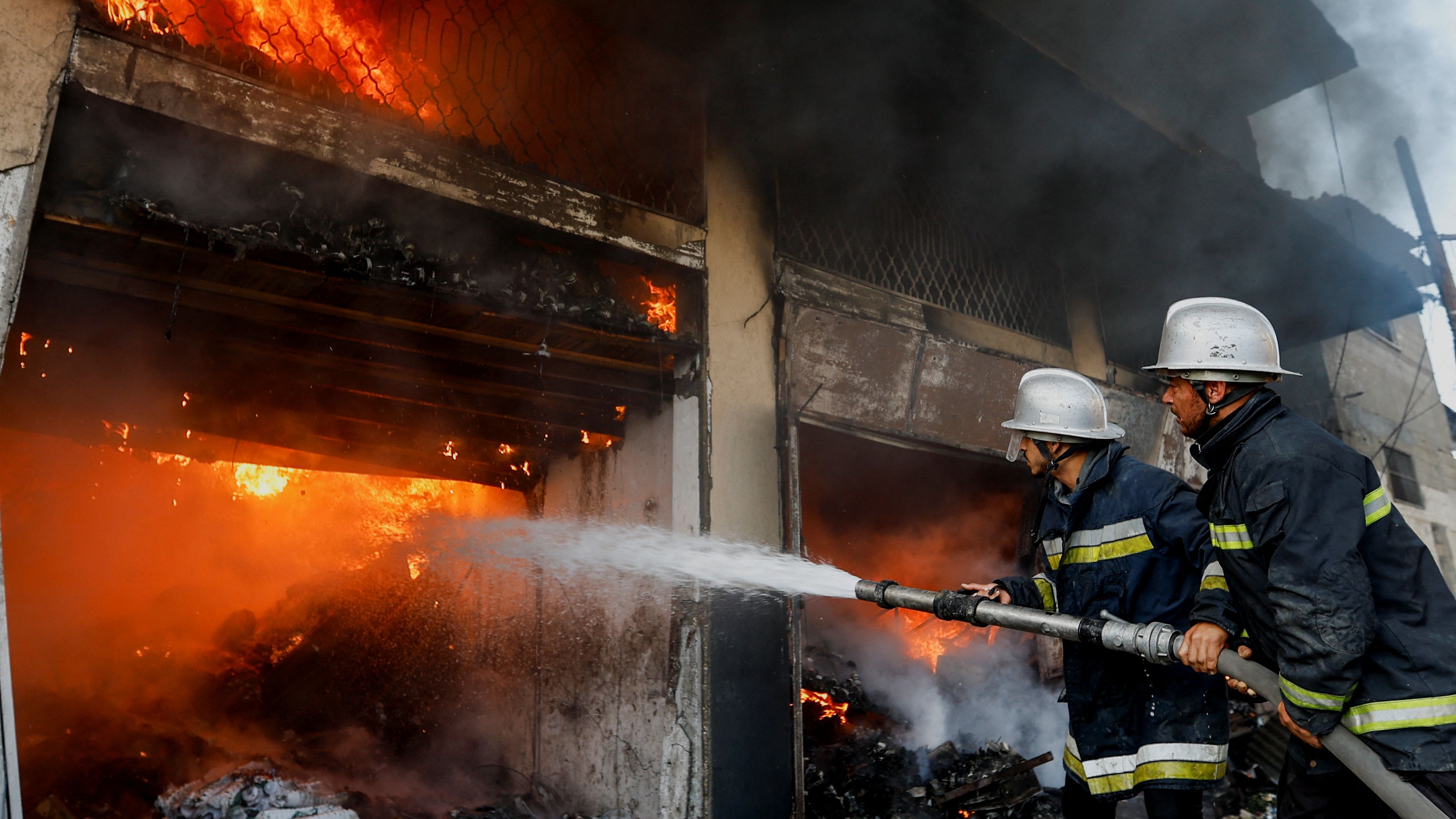 Palestinian firefighters battle after an Israeli strike in Khan Younis in the southern Gaza Strip./ Iraheem Abu Mustafa/Reuters