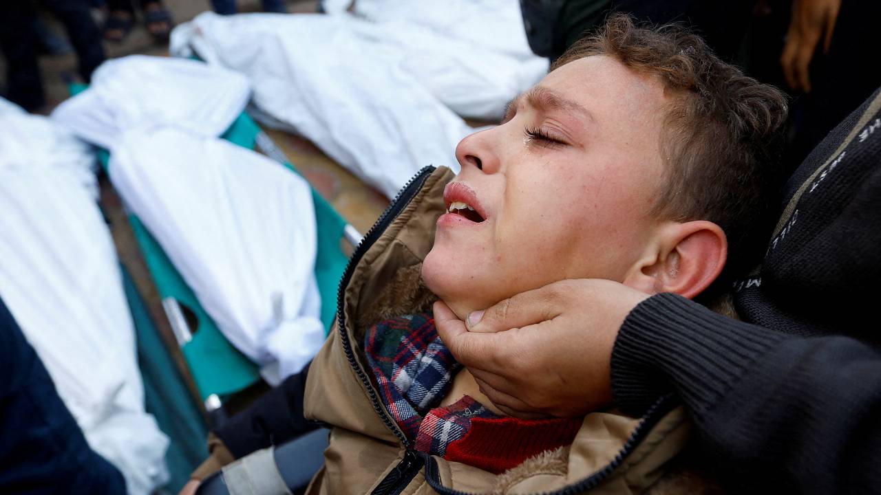 A Palestinian boy, injured in an Israeli raid, reacts as he attends the funeral of family members who were killed in the attack. /Ibraheem Abu Mustafa/Reuters