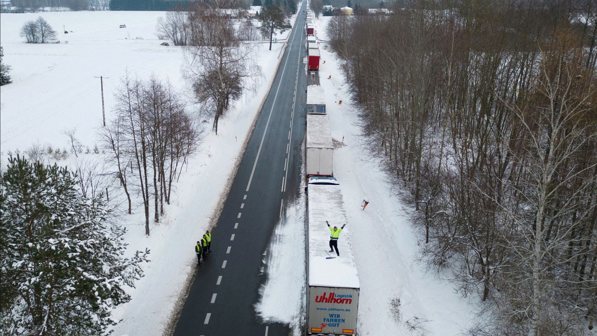  A truck driver from Ukraine waves from his truck roof while waiting in a long queue to cross the Polish-Ukrainian border at the Dorohusk-Jagodzin crossing, in Okopy, Poland on December 4. /Kuba Stezycki/File Photo/Reuters