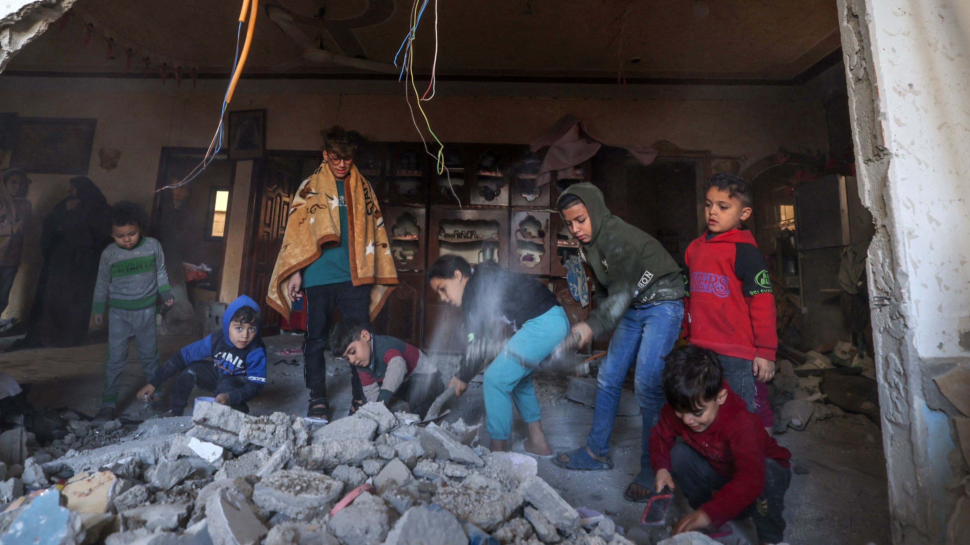 Palestinian children search through rubble in Rafah in the southern Gaza Strip. /Mohammed ABED/AFP