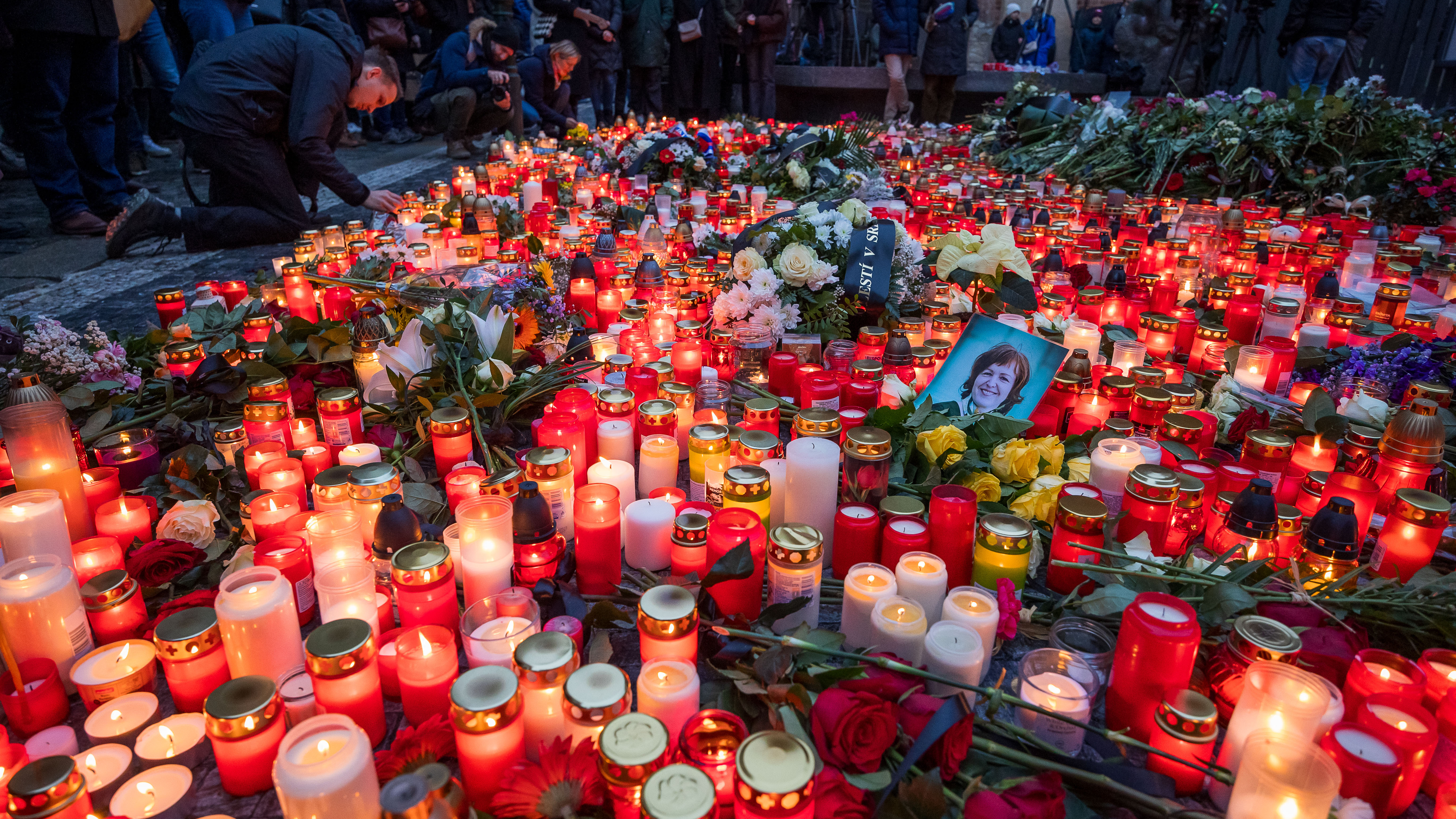 Candles and flowers are placed at a makeshift memorial for the the victims, outside the Charles University in central Prague. /Michal Cizek/AFP