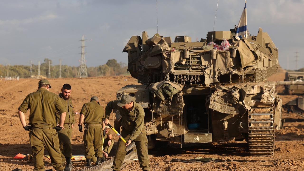 Israeli soldiers gather around tanks near the border with the Gaza Strip in southern Israel. /Menahem Kahana/AFP