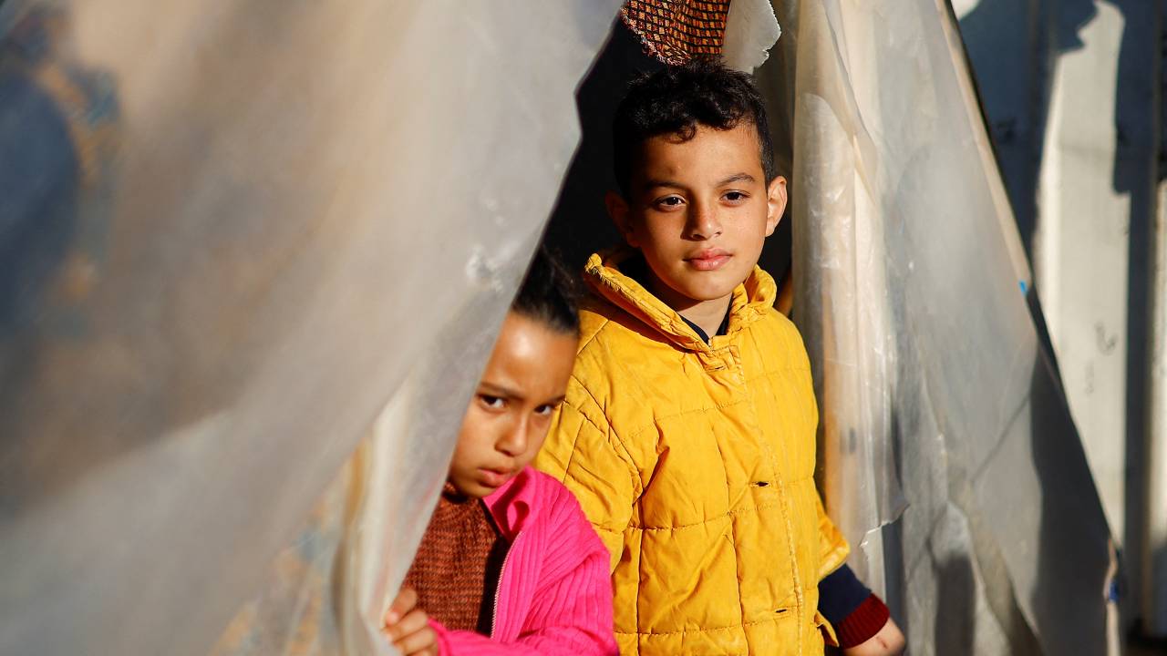 Ahmed and Rahaf, the children of a deaf couple who fled their house due to Israeli strikes, take shelter in a tent camp in Rafah. /Ibraheem Abu Mustafa/Reuters