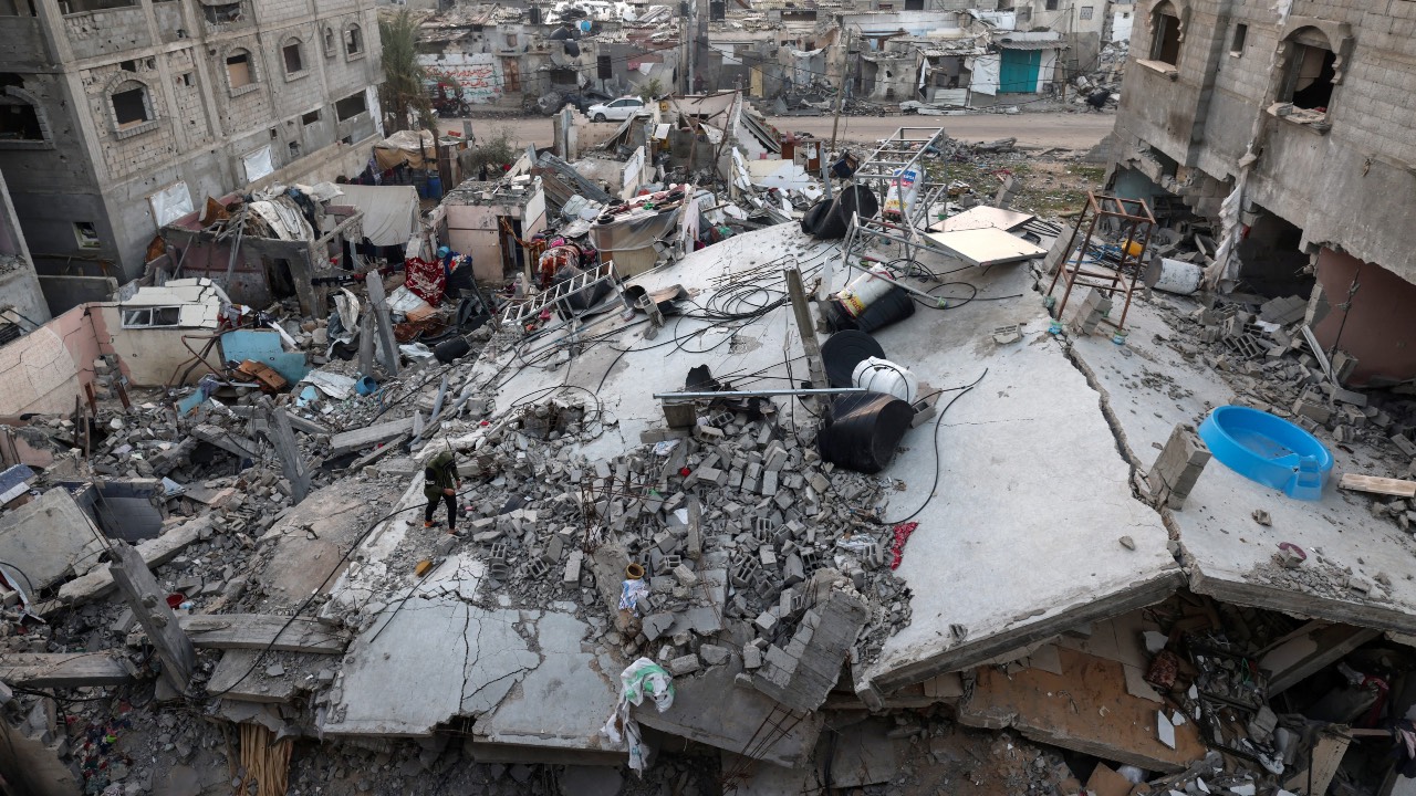 A Palestinian man walking atop the rubble of a collapsed building in Rafah in the southern Gaza Strip. /AFP