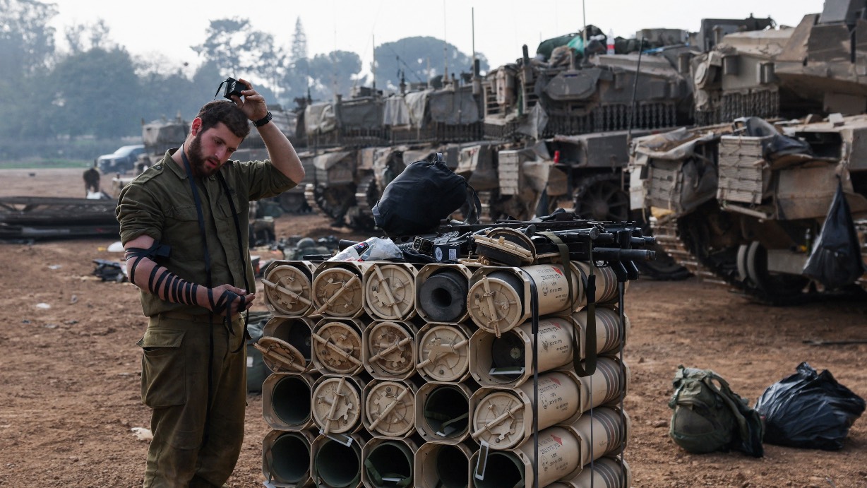 An Israeli soldier prays by tanks near the Israel-Gaza border, in southern Israel. /Violeta Santos Moura/Reuters
