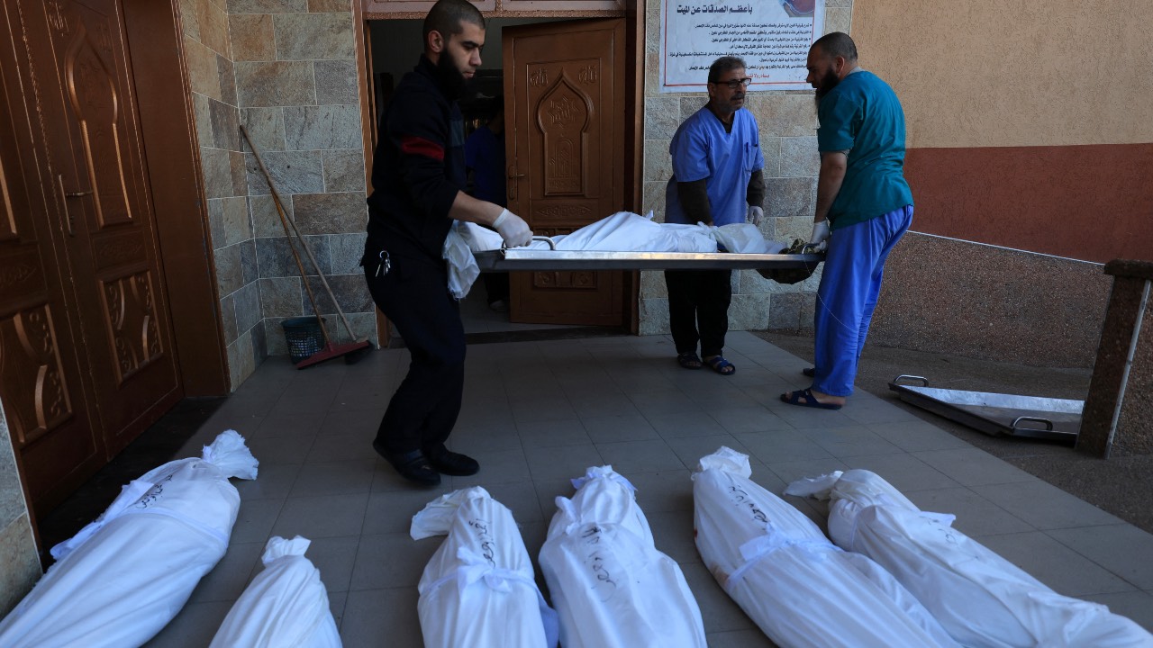 Medics line up bodies of members of the Salah and Abu Hatab families, killed by Israeli bombardment, at Nasser medical center in Khan Younis. /AFP