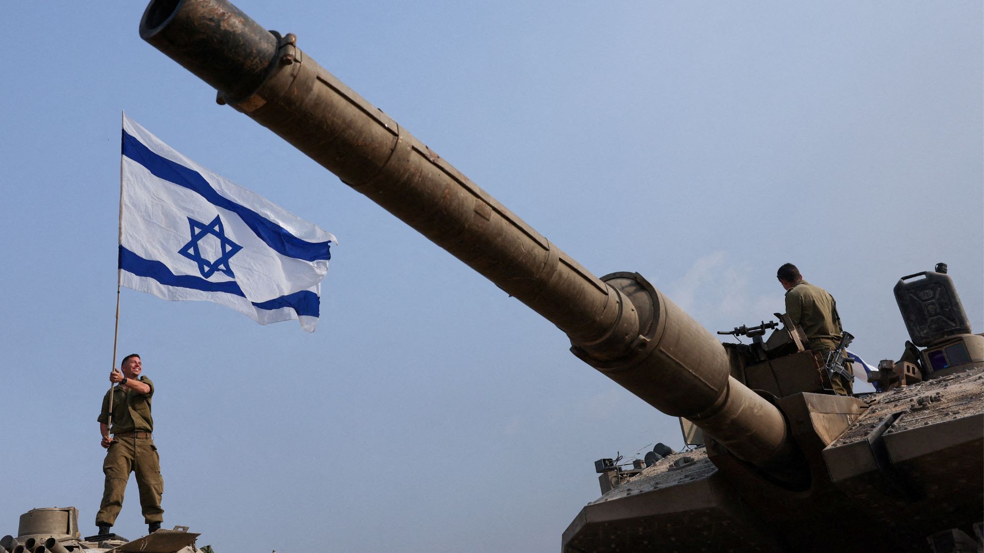 An Israeli soldier waves his country's flag on a tank near the Gaza border in southern Israel. /Reuters