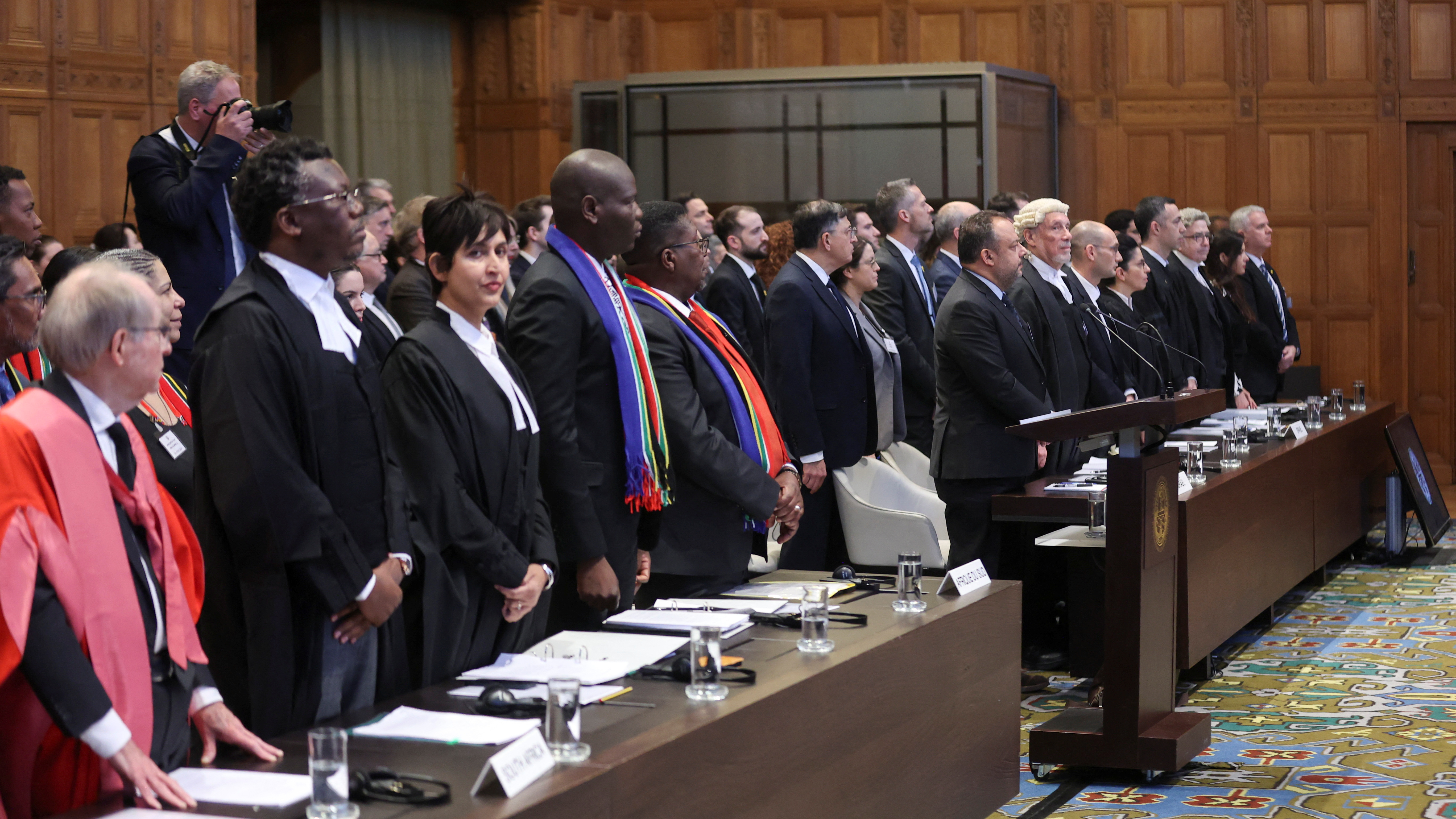 South Africa's Minister of Justice Ronald Lamola, lawyer Adela Hassim and the delegation stand as judges at the International Court of Justice hear a request for emergency measures by South Africa, who asked the court to order Israel to stop its military actions in Gaza. /Thilo Schmuelgen/Reuters