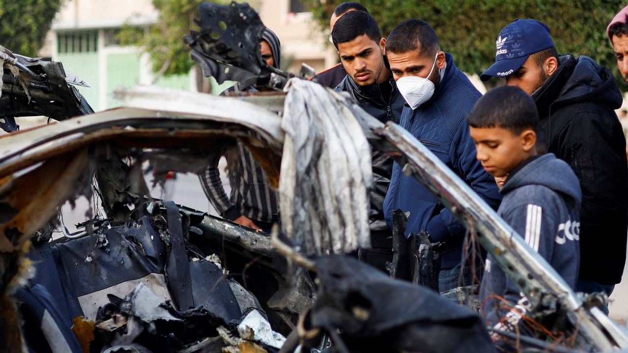 Palestinians inspect the remains of a car in the aftermath of an Israeli strike in Rafah in the southern Gaza Strip. /Ibraheem Abu Mustafa/Reuters