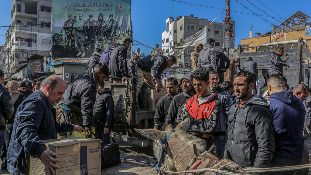 Men gather to unload supplies near the Rafah border crossing./Abed Rahim Khatib/CFP