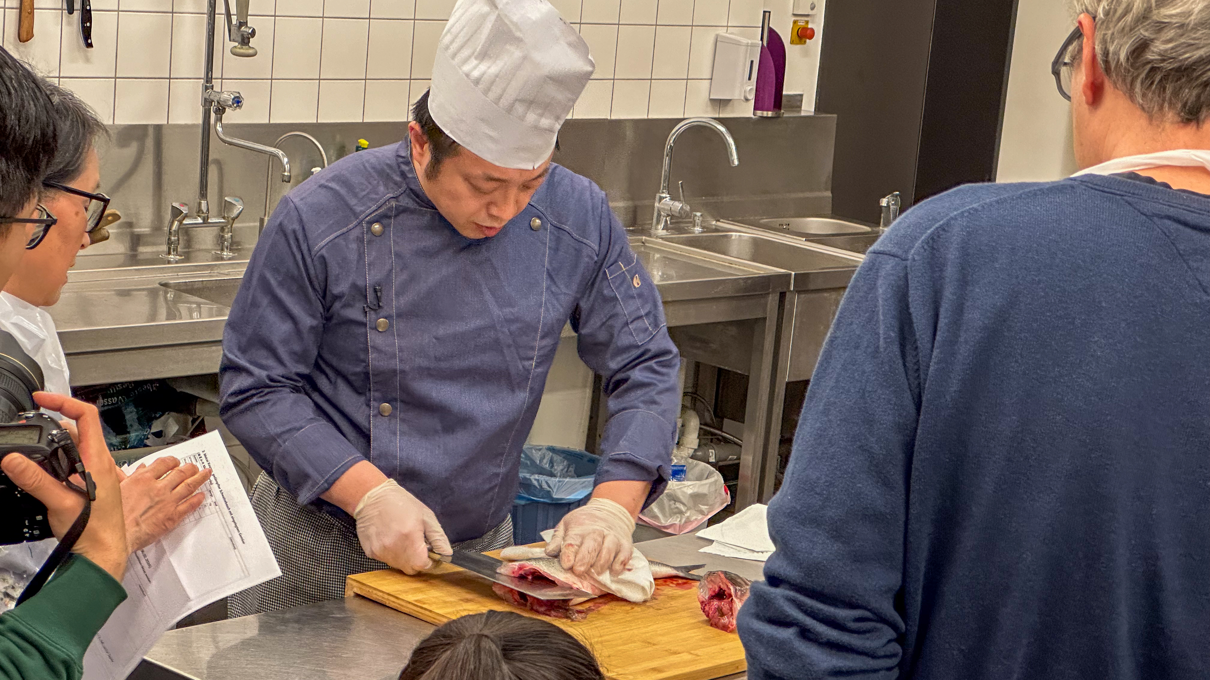Attendees at Berlin's Chinese Culture Centre watch a chef prepare dishes. /CGTN