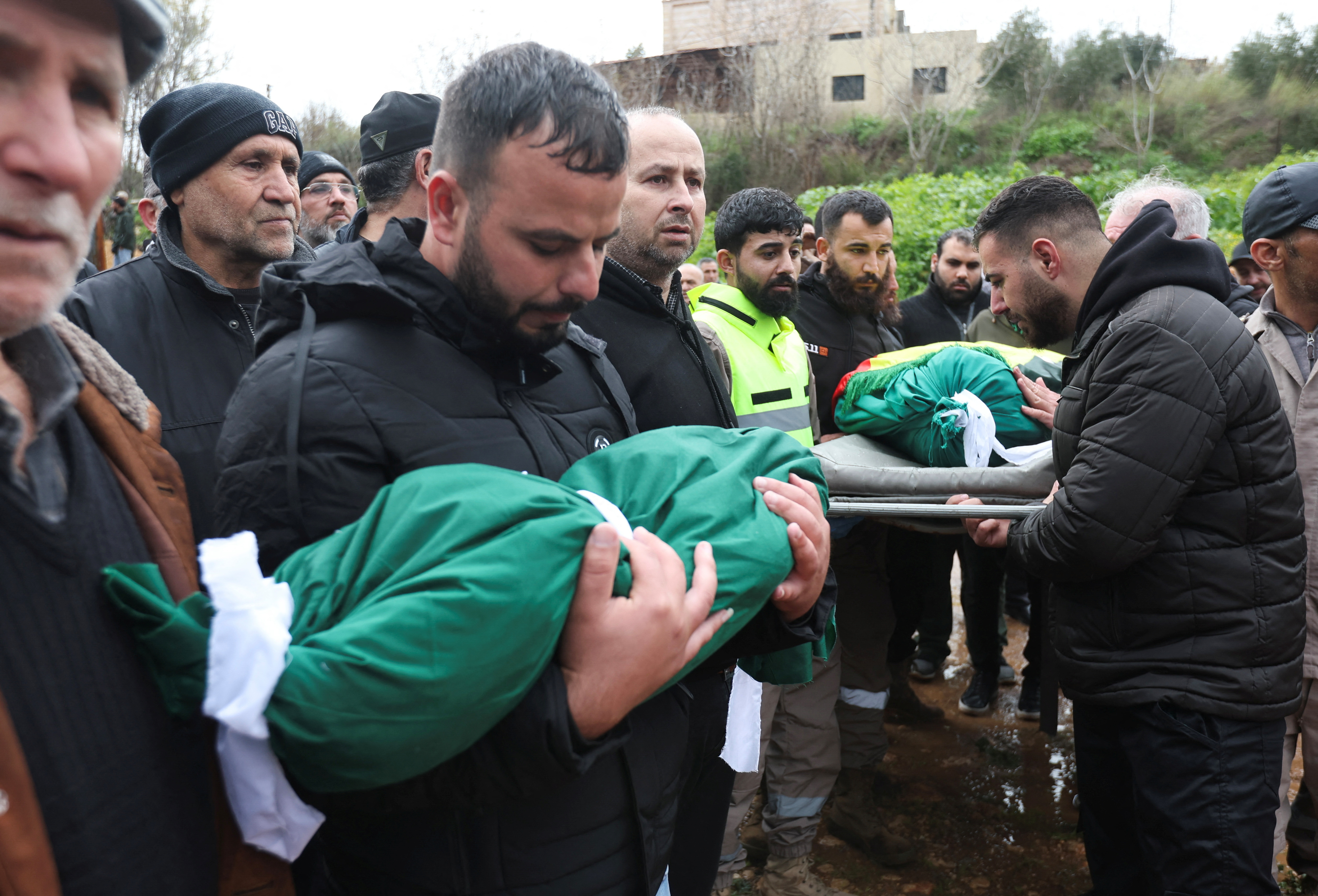 Jalal Mohsen holds the body of his child, who, according to security sources, was killed during an Israeli strike, during the funeral in Qantara./ Reuters/Aziz Taher.
