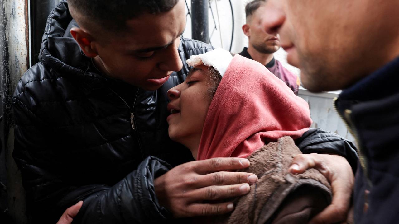 A Palestinian injured in an Israeli strike mourns the death of her sibling at a hospital in Rafah in southern Gaza. /Ibraheem Abu Mustafa/Reuters