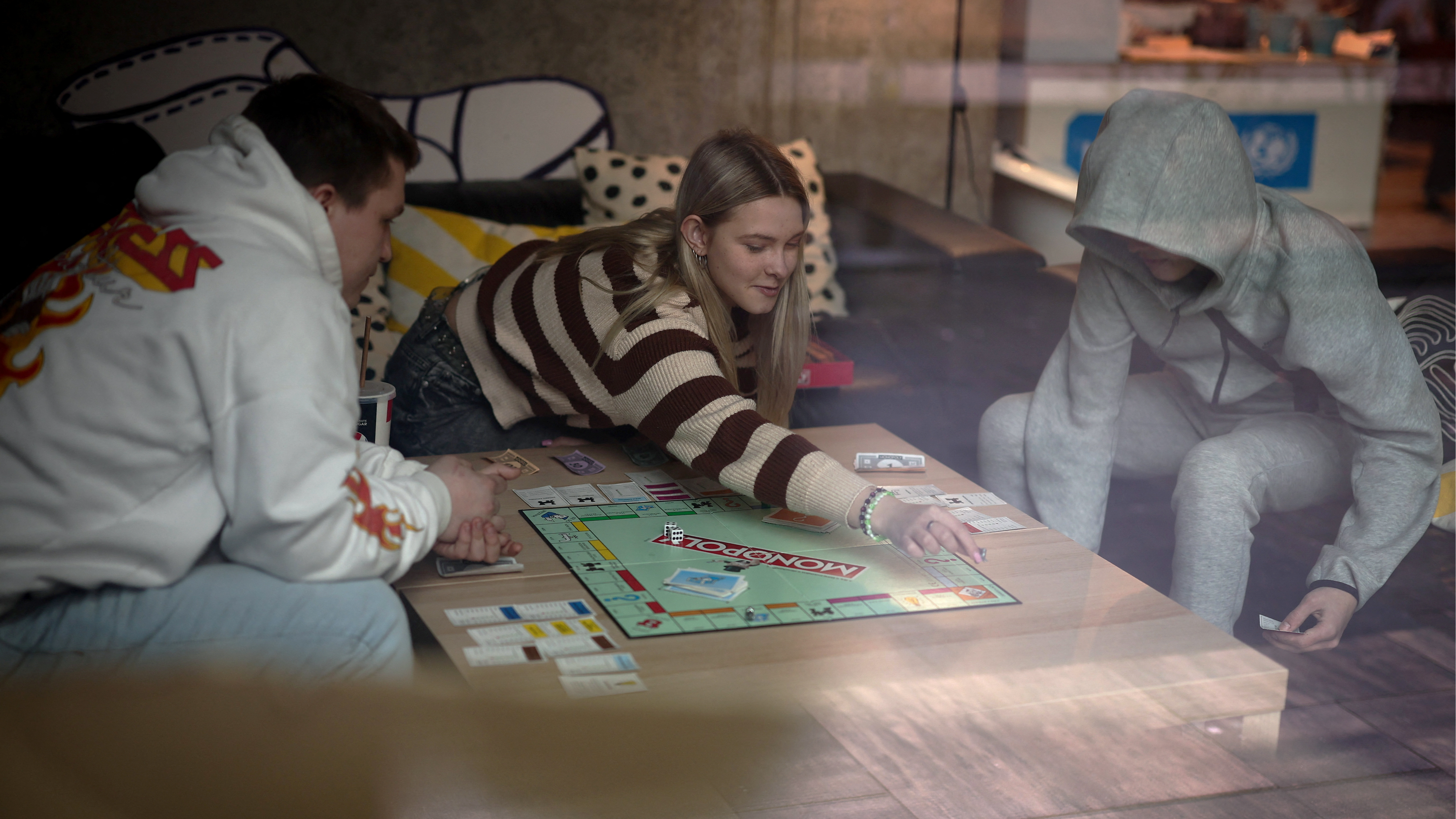 Dariia Vynohradova, 17, from Kharkiv, plays a board game with her boyfriend Dmytro Demchevskyi, 18, from Yuzhnoukrainsk, at Blue Trainers, a community space in a shopping mall in Gdansk, Poland. /Kacper Pempel/Reuters
