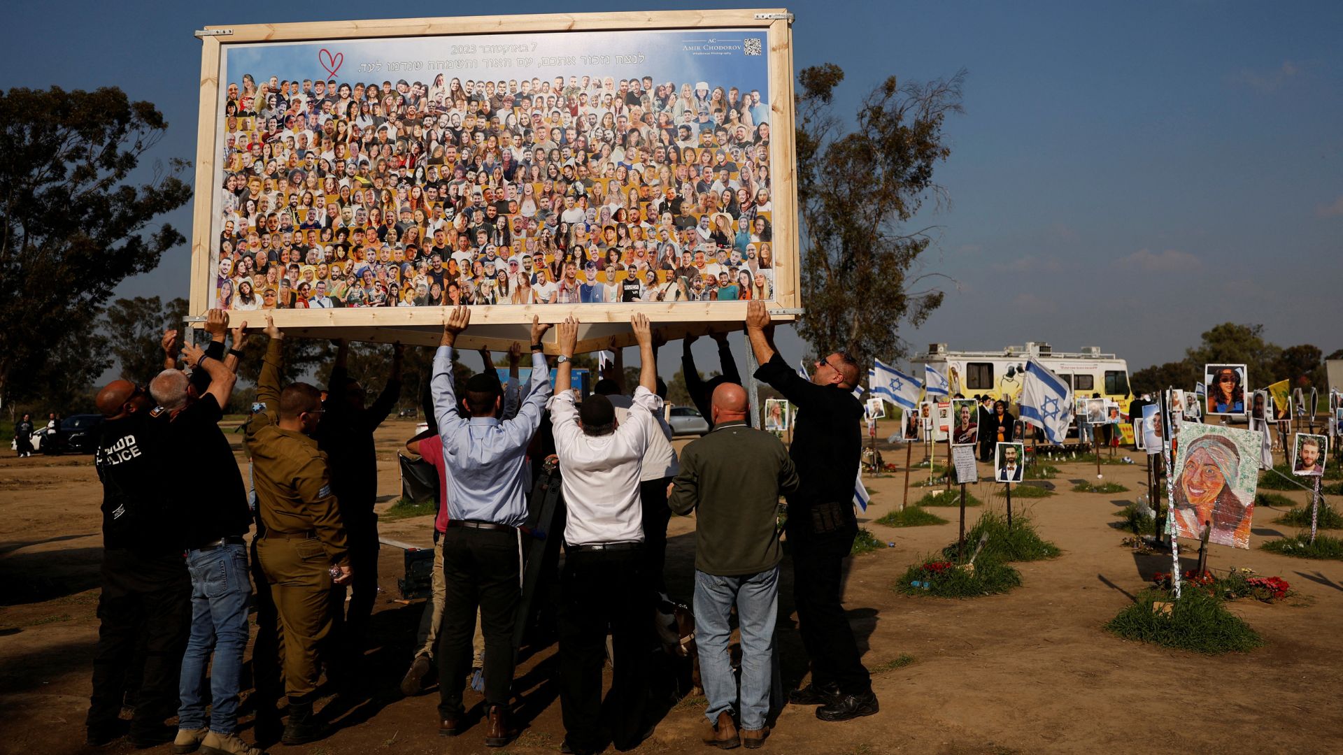 People help to raise a collage by artist Amir Chodorov depicting the faces of the Nova party victims, amid the ongoing conflict between Israel and Hamas, in Reim, southern Israel. /Susana Vera/Reuters
