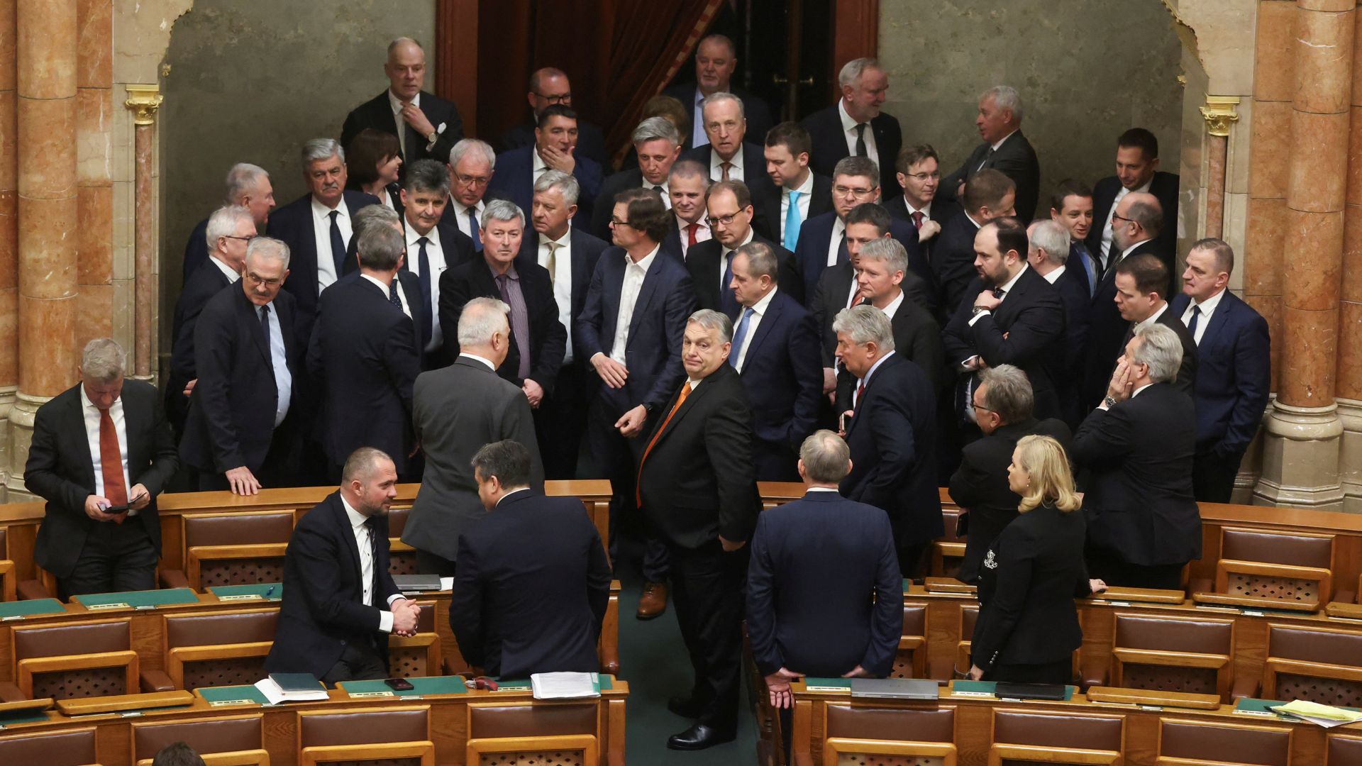 Hungarian Prime Minister Viktor Orban and members of the Fidesz party stand together during a break in parliament on Monday. /Bernadett Szabo/Reuters
