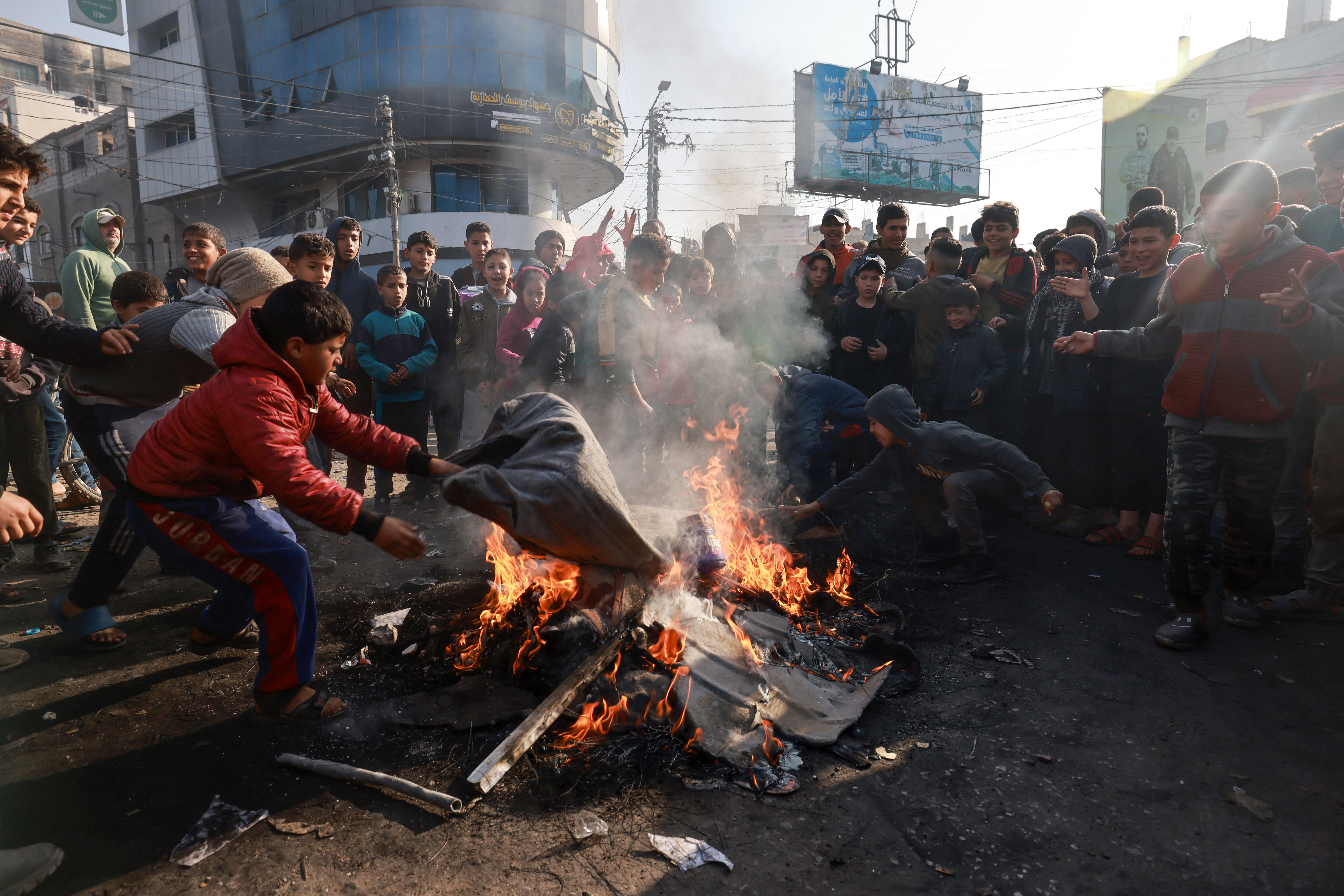 Palestinian children burn tires in protest against the rising prices of food and supplies due to shortages, in the Rafah refugee camp in the southern Gaza Strip. February 28, 2024. MOHAMMED ABED / AFP