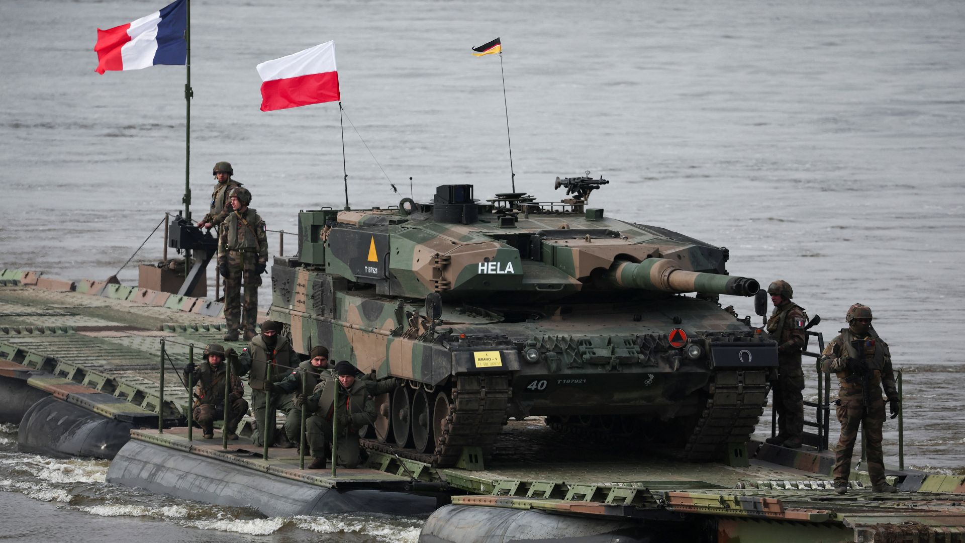 French soldiers transport Polish soldiers on a Leopard 2Es tank across the Vistula River in Korzeniewo, Poland. /Kacper Pempel/Reuters
