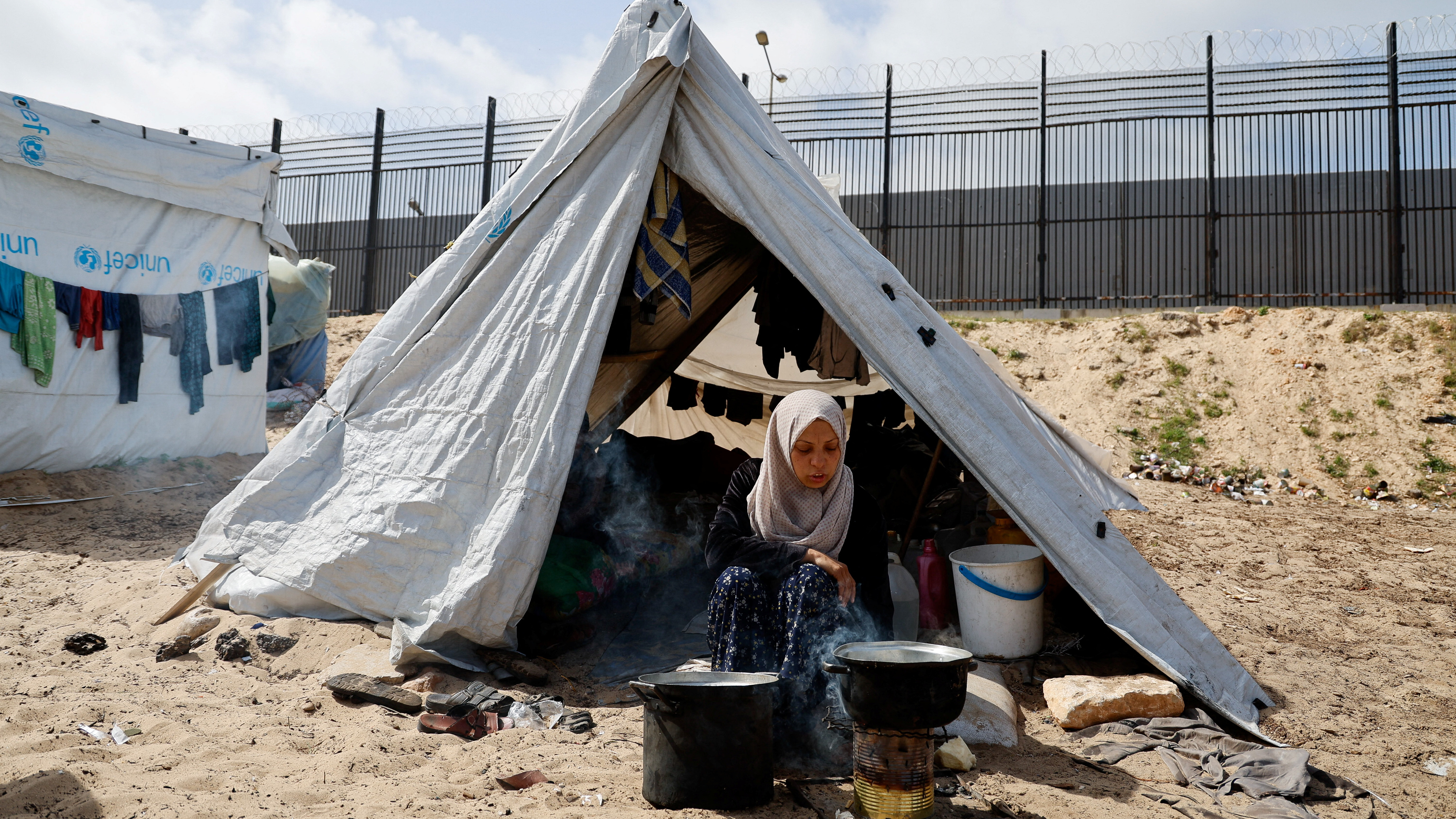 A displaced palestinian woman sits in a tent near the Rafah border /Mohammed Salem/Reuters