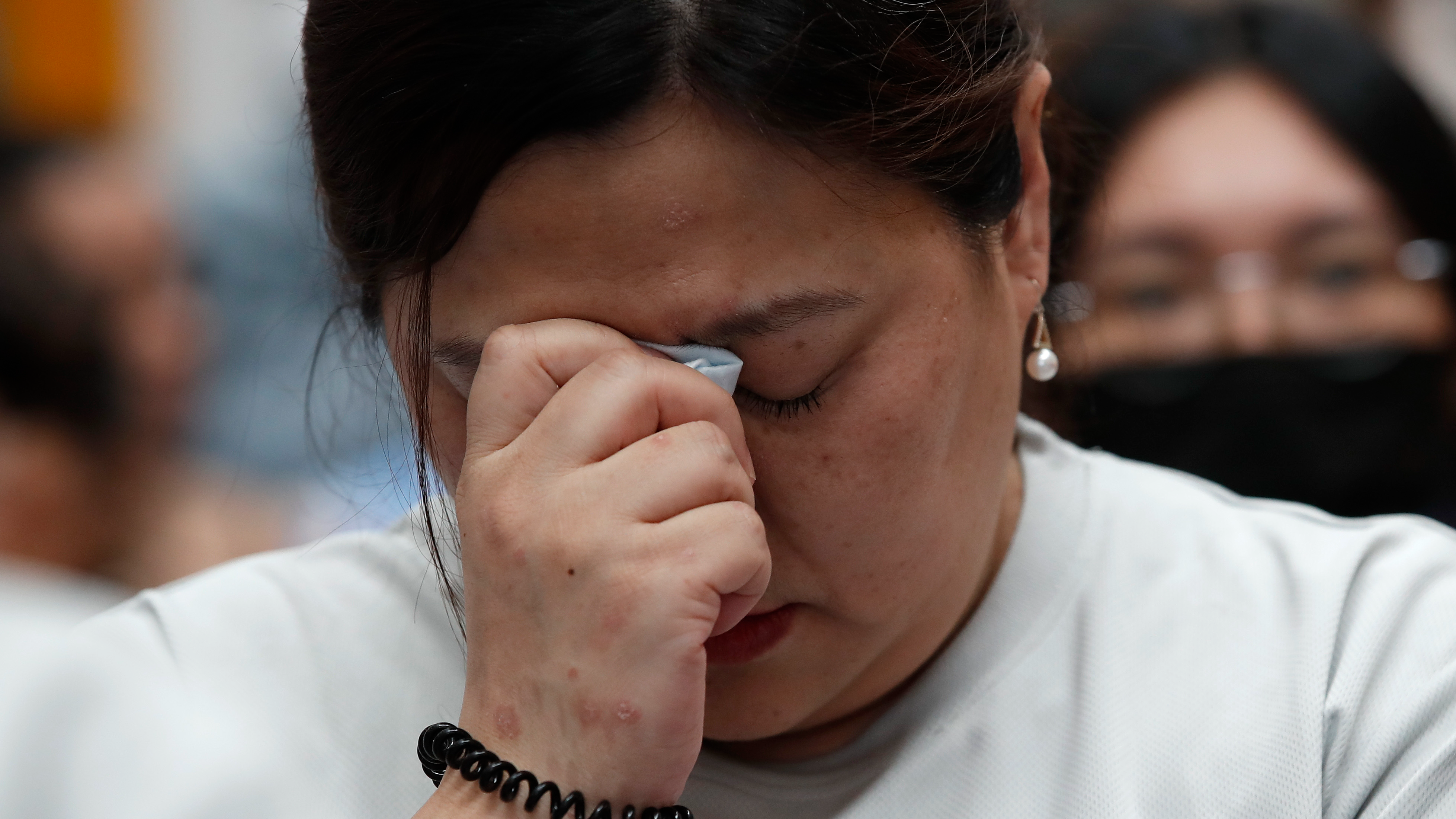 A family member of an MH-370 passenger breaks down in tears at an event marking 10 years since the tragedy. /FL Wong/AP