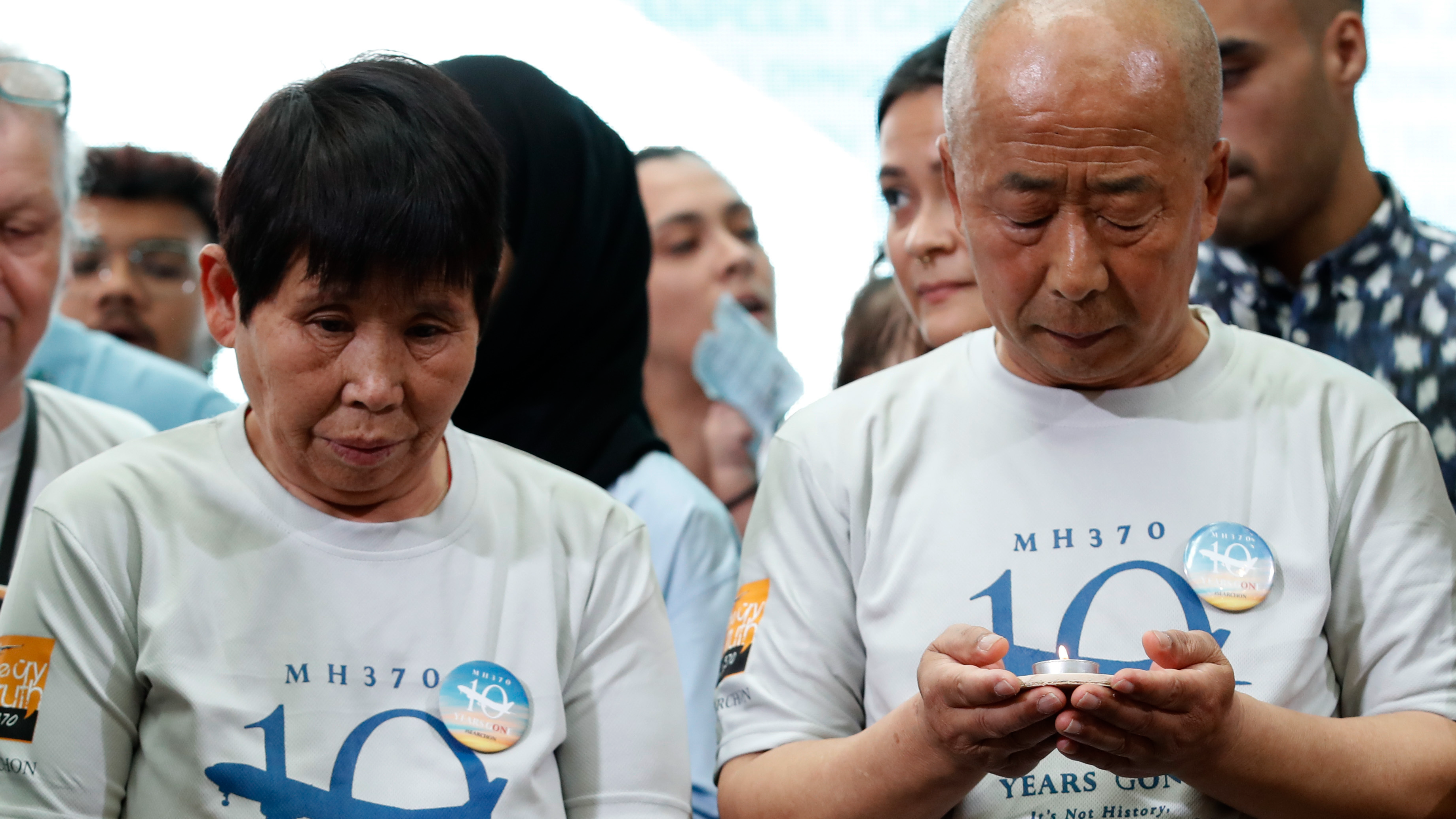Family members of MH-370 passengers stand for a moment of silence at a memorial event in Kuala Lumpur on March 3. /FL Wong/AP