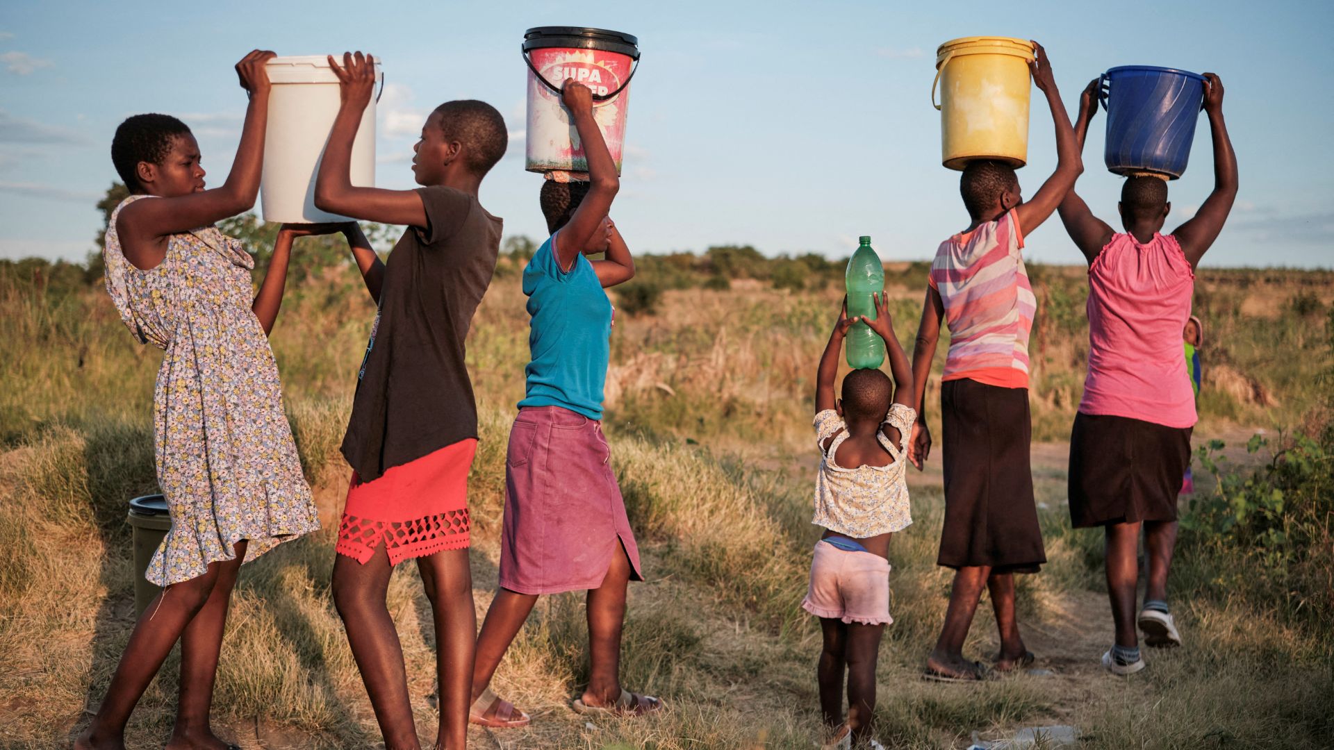 Residents of Pumula East township walk home after fetching water from a well, as temperatures soar during an El Nino-related heatwave and  in Bulawayo, Zimbabwe last week. /KB Mpofu/Reuters