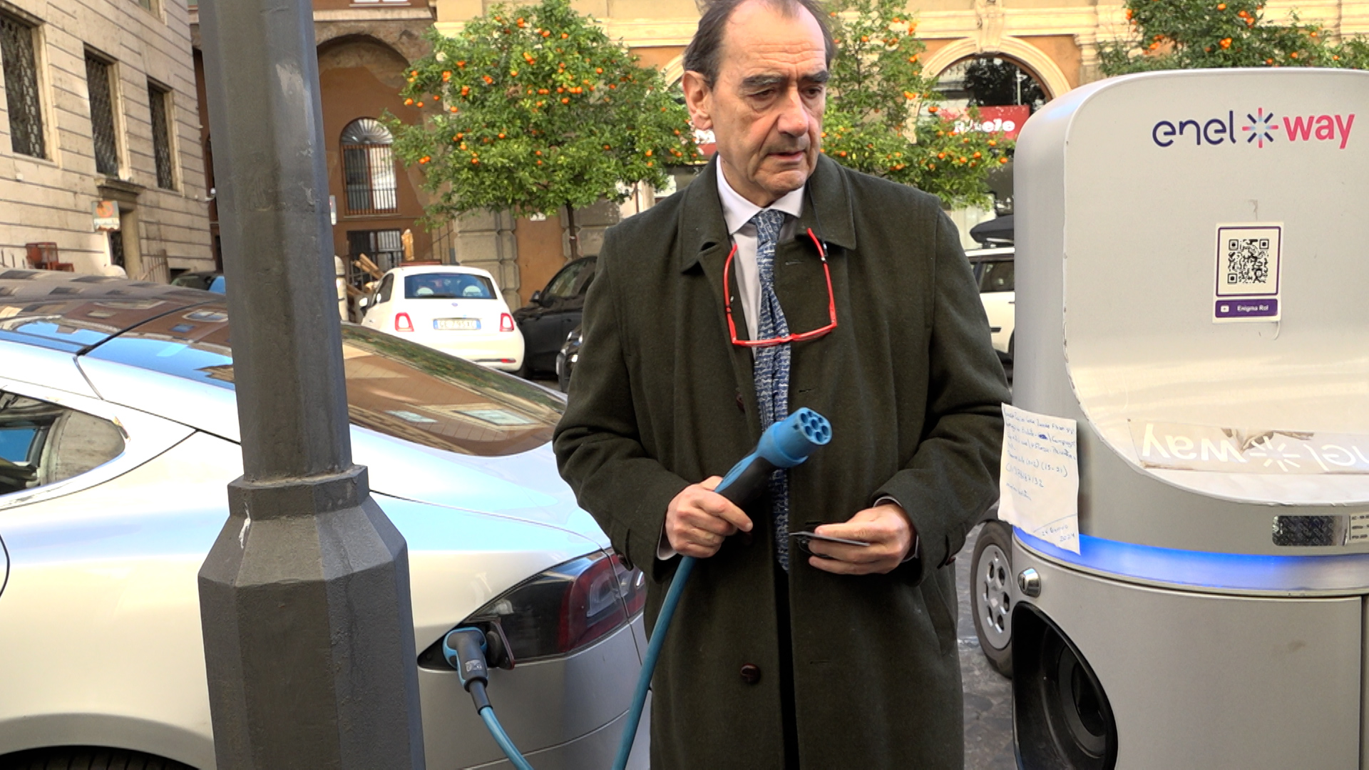 Giuseppe Pugliese charging his electric car in central Rome. /CGTN
