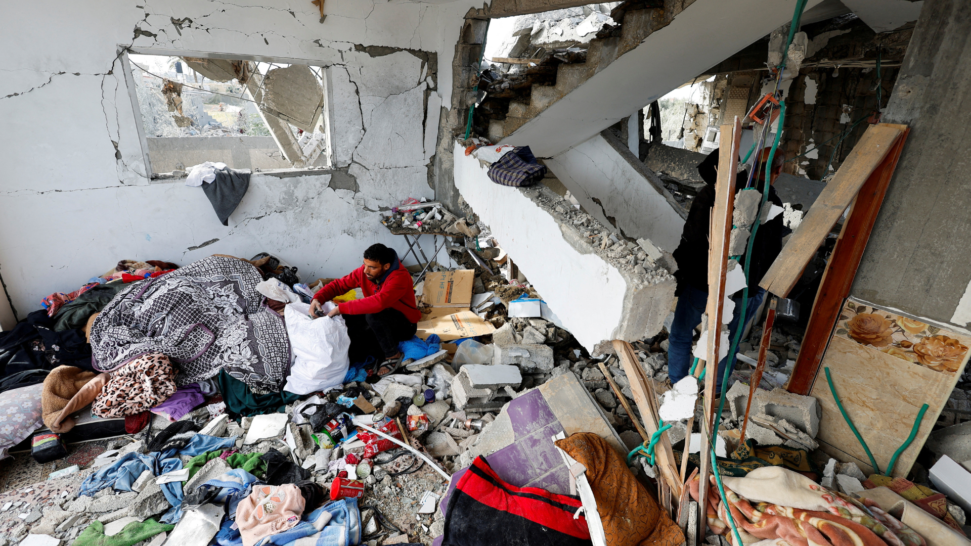 A Palestinian man retrieves belongings from the site of Israeli strikes on a house in Rafah. /Mohammed Salem/Reuters