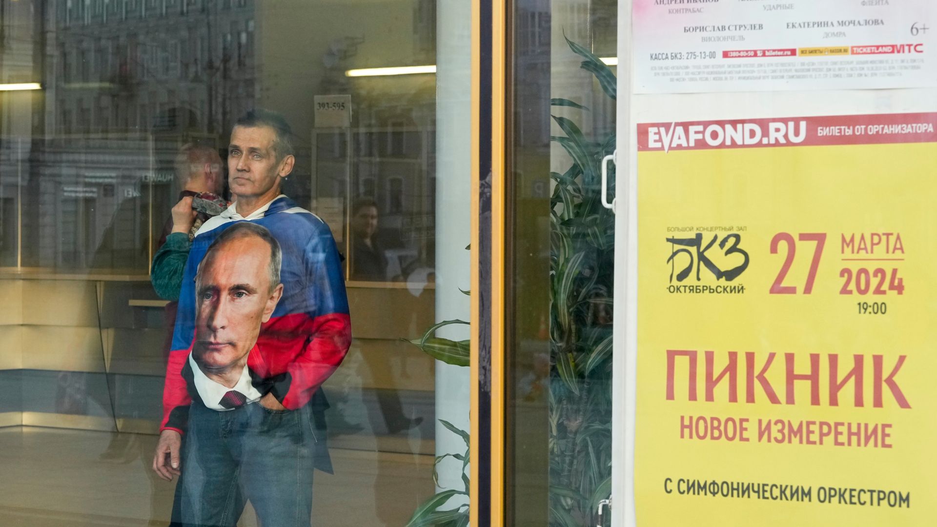 A man looks through a window as police guard the Oktyabrsky Concert Hall ahead of Picnic's memorial concert. /Dmitri Lovetsky/AP