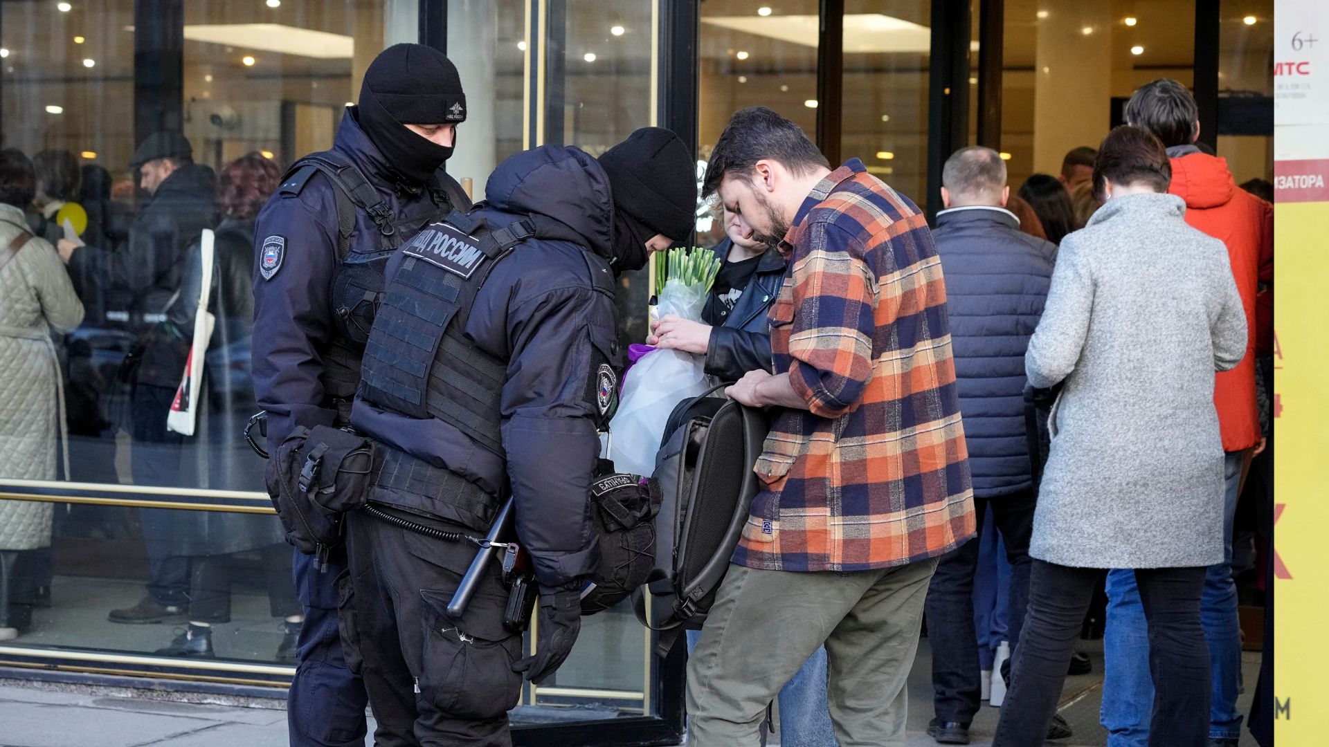 Riot police inspect bags as people gather for a memorial concert in honor of the Crocus attack victims. /Dmitri Lovetsky/AP
