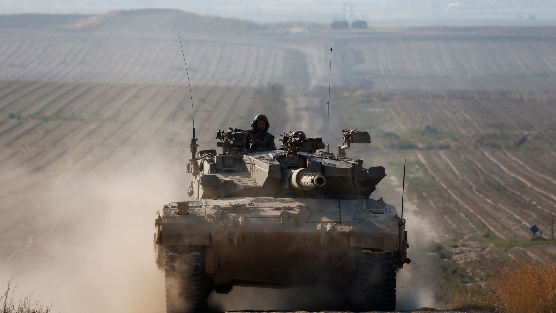 An Israeli tank maneuvers near the border with Gaza – but more troops have withdrawn. /Amir Cohen/Reuters