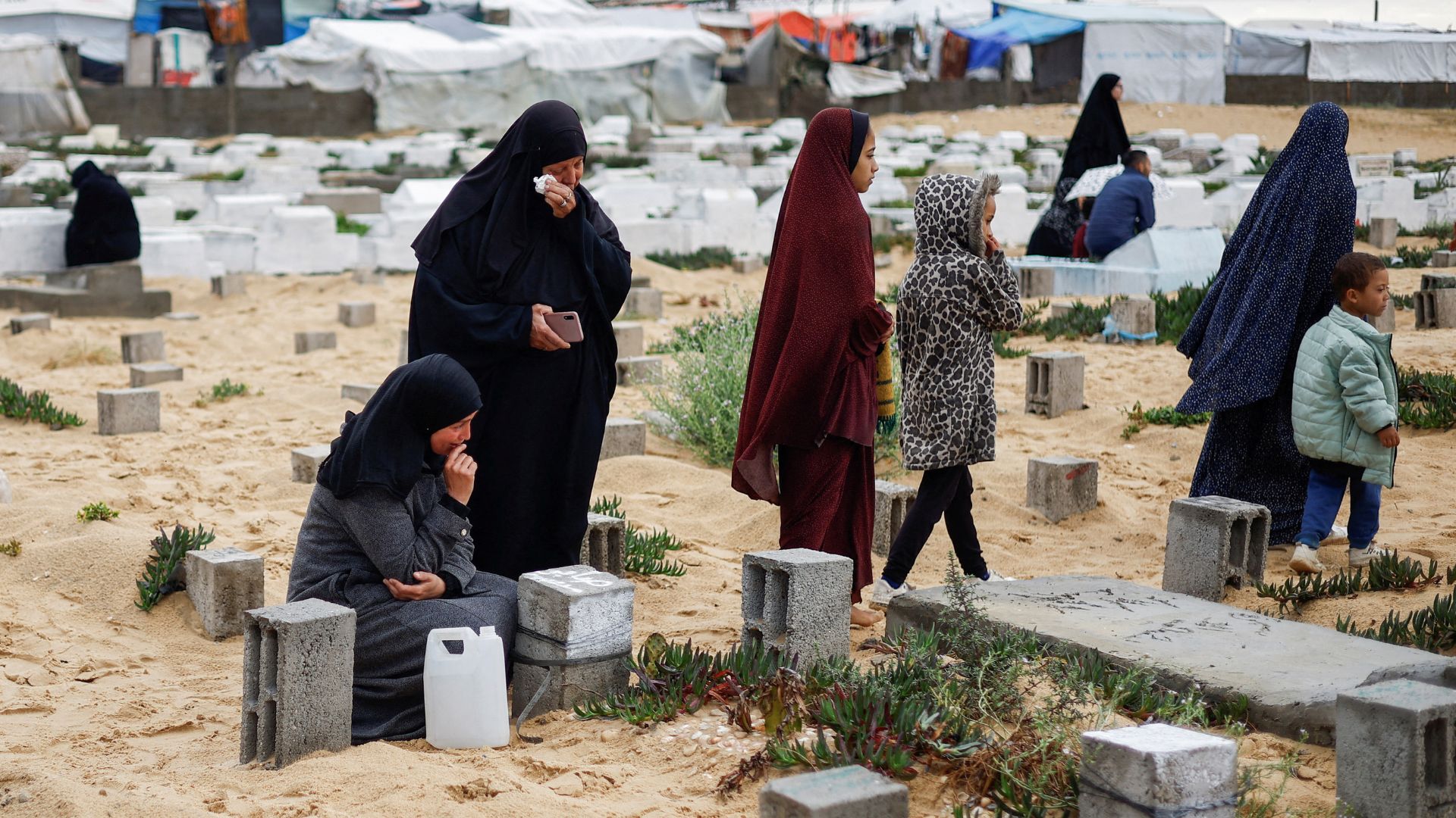 Palestinian women visit graves of people who were killed, in Rafah. /Mohammed Salem/Reuters