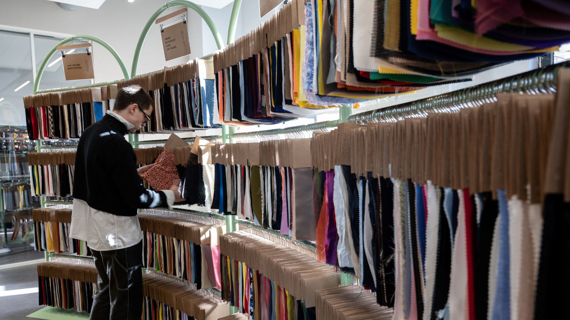 Spanish designer Arturo Obegero looks at fabrics in the Nona Source showroom. /Bertrand Guay/AFP