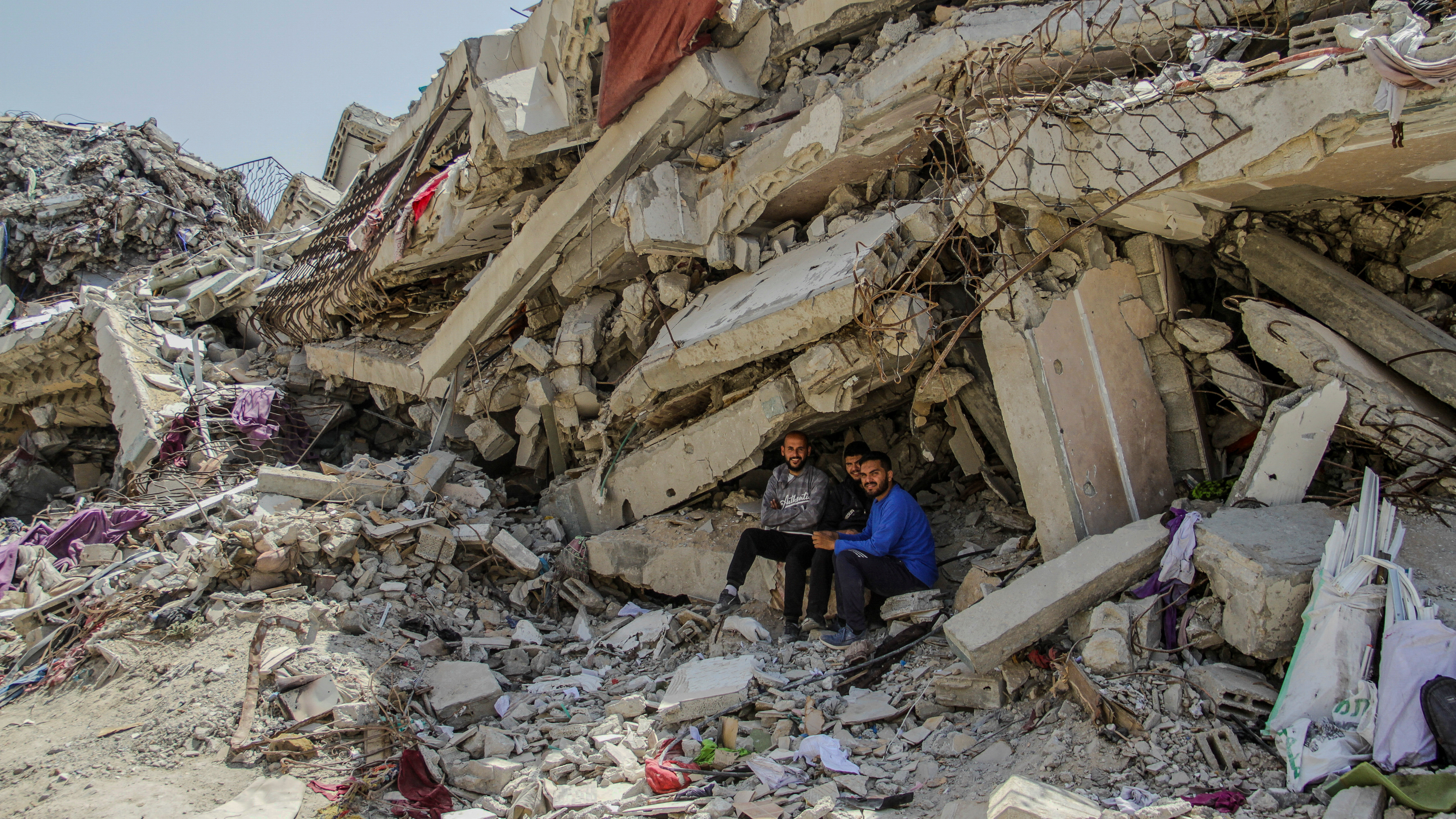 Gazan residents rest in the shade of a collapsed building /Mahmoud Issa/Reuters