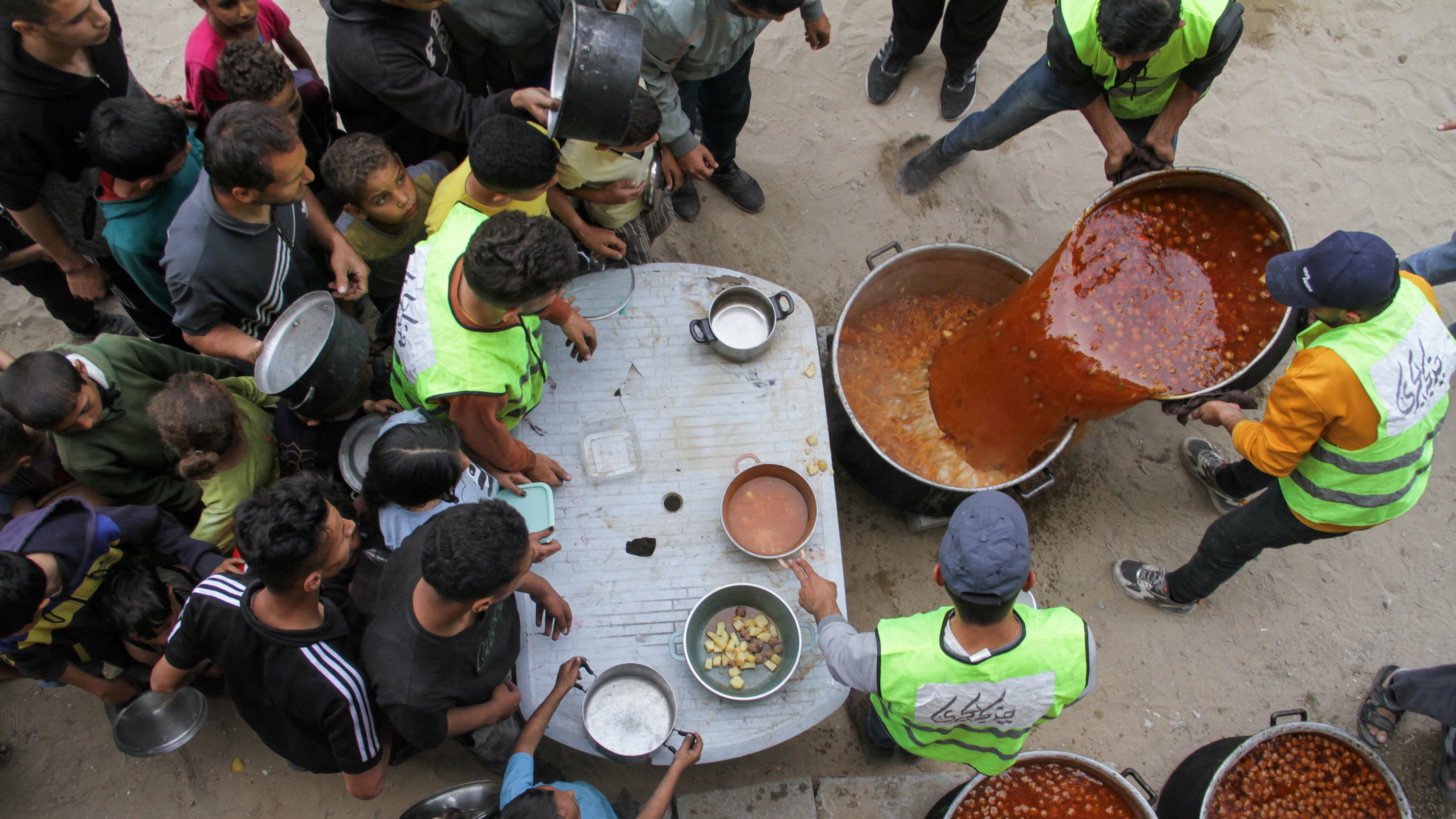 Volunteers feed displaced families in Jabalia./Mahmoud Issa/REUTERS