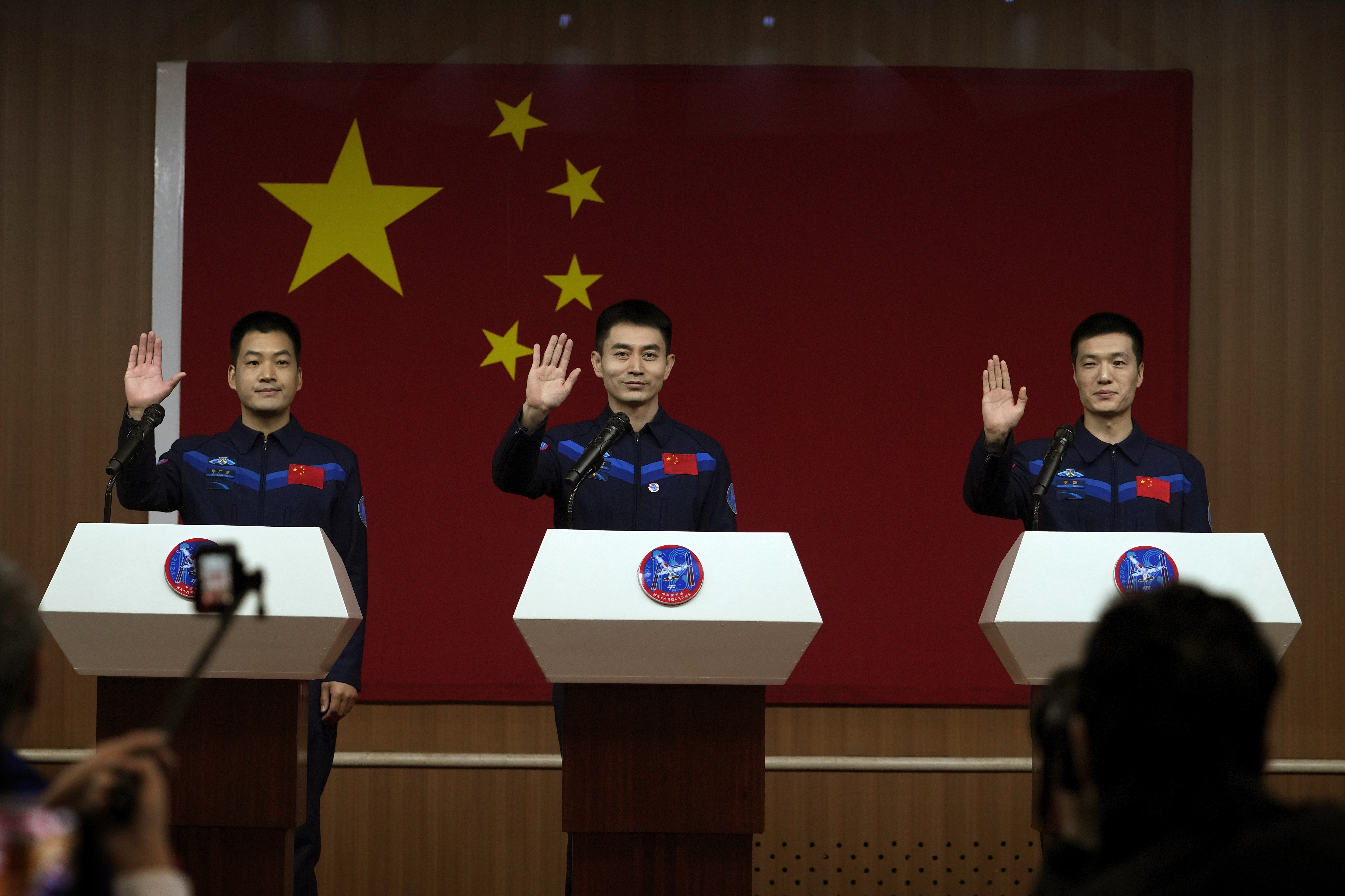 Chinese astronauts for the upcoming Shenzhou-18 mission, Li Guangsu, Ye Guangfu and Li Cong wave as they arrive for a meeting at the Jiuquan Satellite Launch Center in northwest China, April 24, 2024./Andy Wong/AP