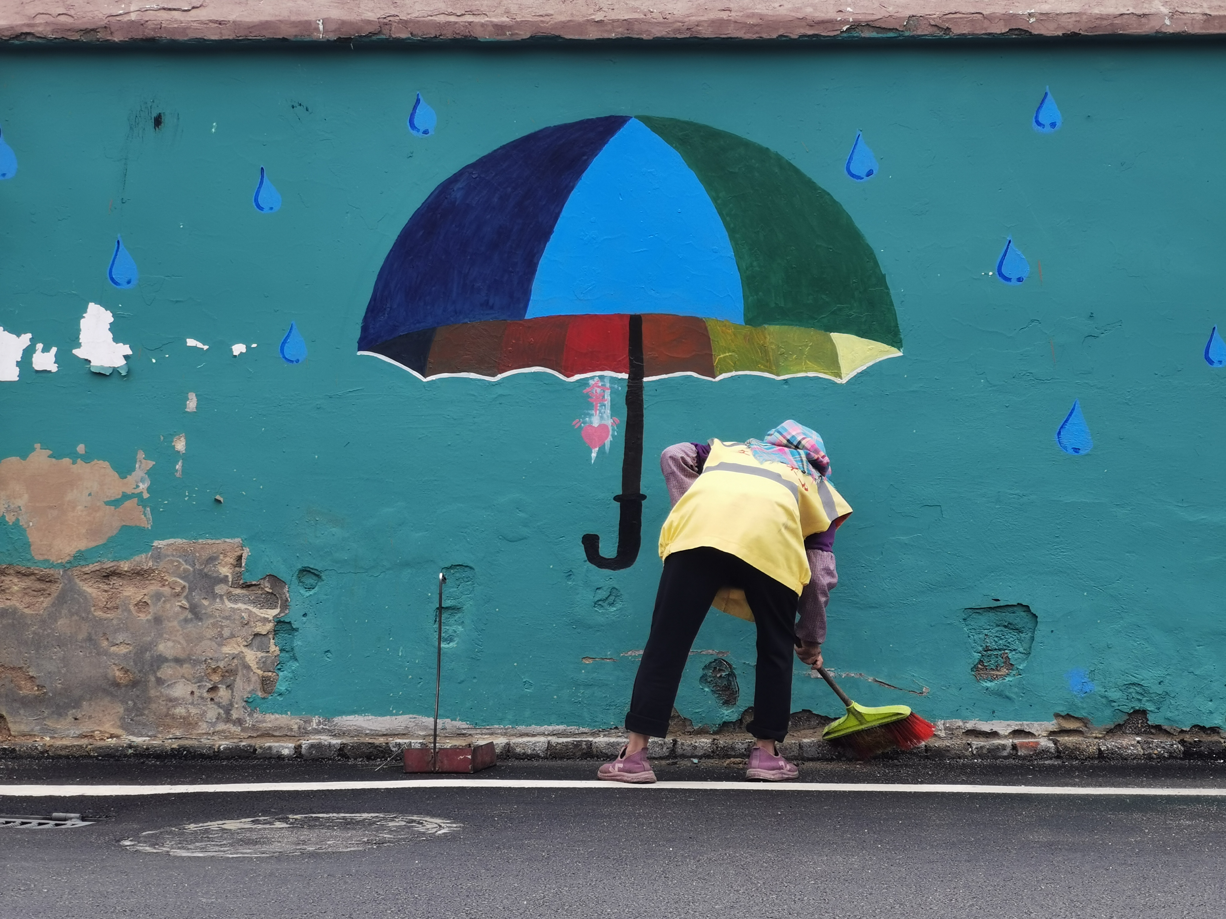 The Chinese winner 'Love in a Small Town' is an amusing juxtaposition of wall art and street cleaning. /Hongwei Zhang